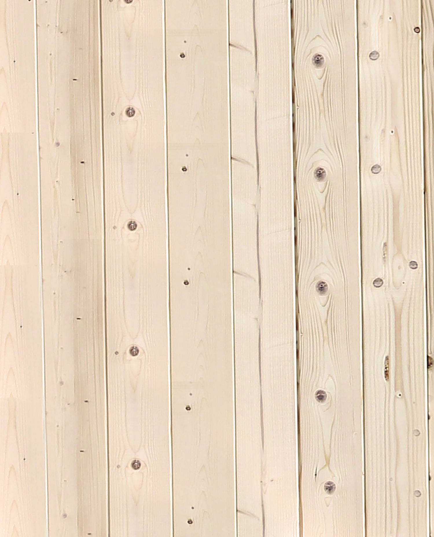 Primer plano de tablas de madera verticales. Las tablas son de color marrón claro con vetas y nudos de madera visibles. El fondo es de madera lisa.