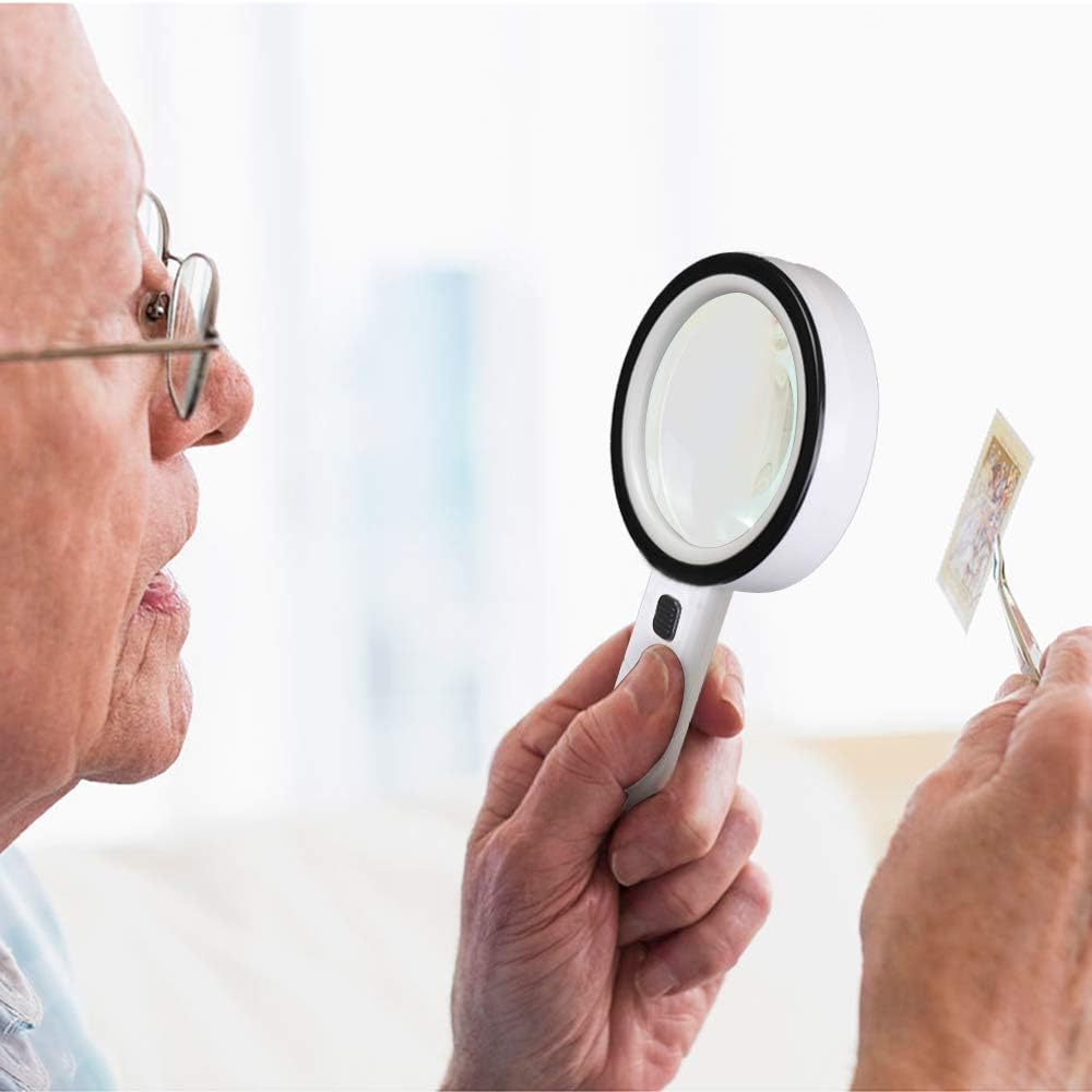 Ein älterer Mann mit Brille betrachtet eine Briefmarke mit einer Lupe. Der Hintergrund ist ein weiches, verschwommenes Weiß.