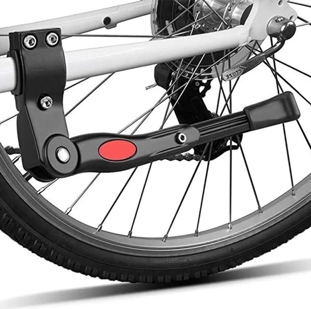 Schwarzer Fahrradständer mit rotem ovalen Knopf, am Hinterrad befestigt. Nahaufnahme von Rad und Fahrradrahmen.