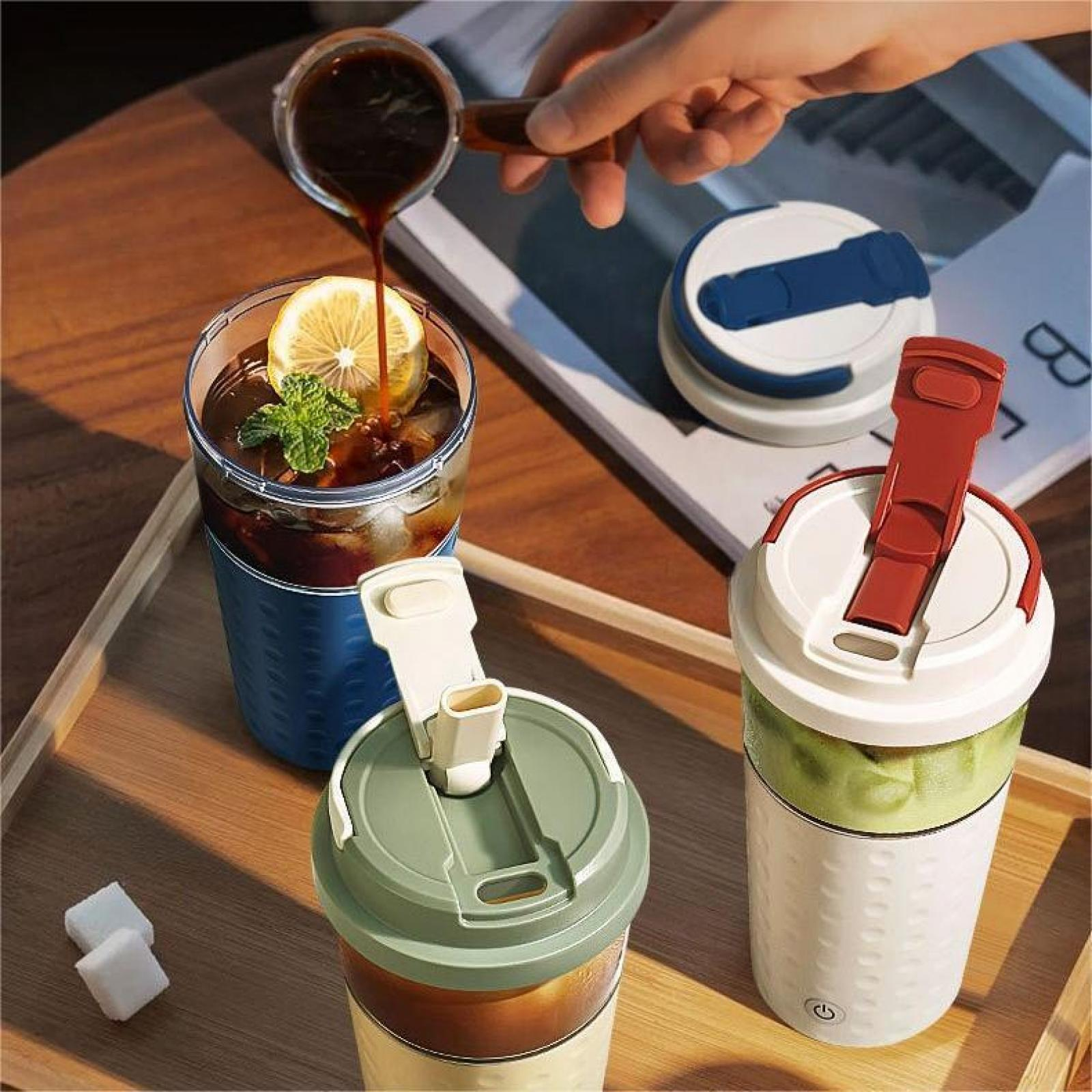 Hand gießt Kaffee in ein Glas mit Zitrone und Minze. Mehrere Getränkebehälter stehen auf einem Holztablett.