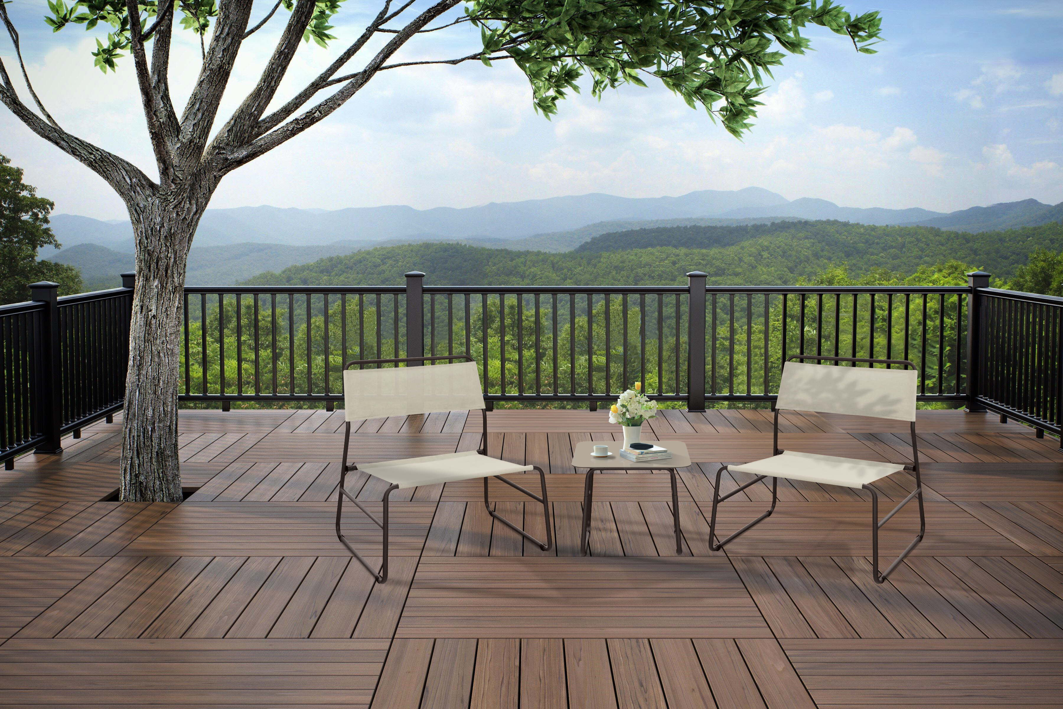 Terrazza con sedie, tavolo e albero. Lo sfondo mostra colline verdi. Il cielo è parzialmente nuvoloso.