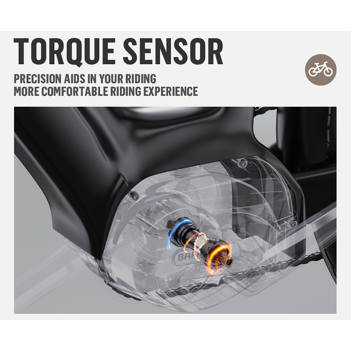 Obraz przedstawia czujnik momentu obrotowego roweru. Tekst: 'TORQUE SENSOR'. Przezroczysty element pokazuje wnętrze czujnika. Rower w tle.