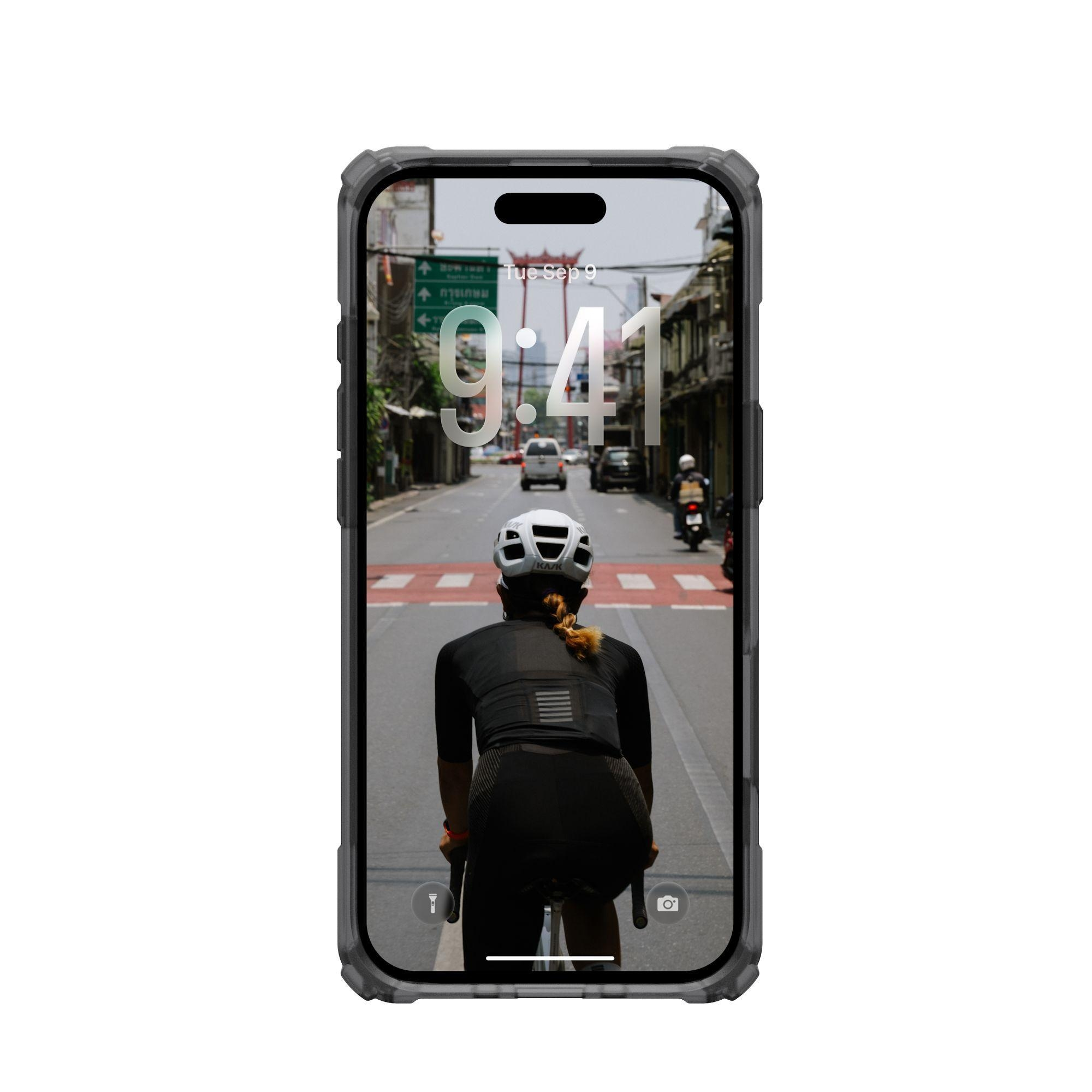 Un ciclista in bici, visto da dietro, percorre una strada. Il telefono mostra la scena. Edifici costeggiano la strada.