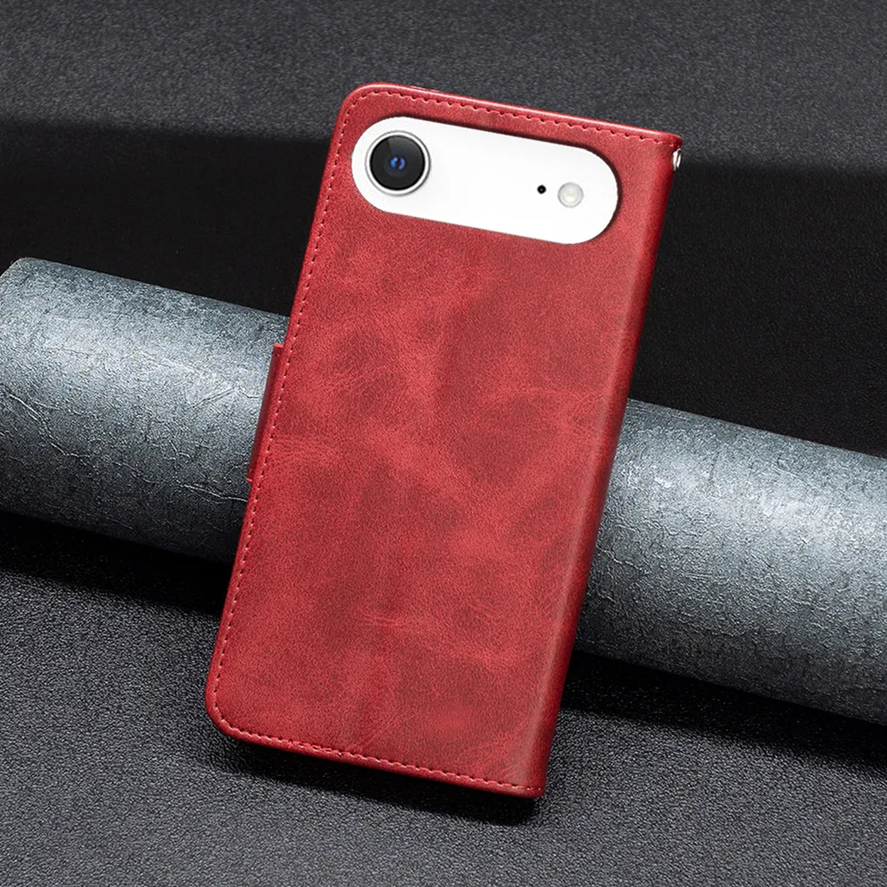 Een rode leren telefoonhoes met een witte uitsparing voor de camera. De achtergrond is donkergrijs en zwart.