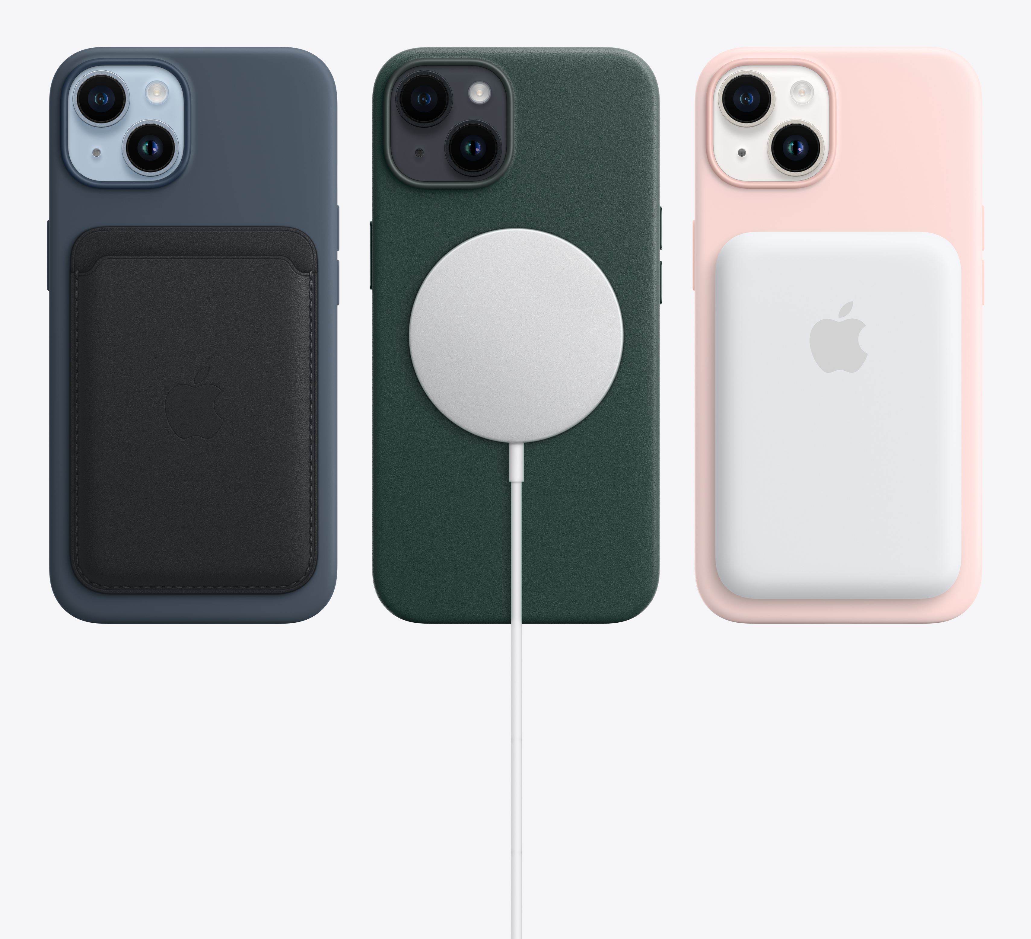 Trzy iPhone'y 14 w etui: granatowy z portfelem, zielony z ładowarką i różowy z baterią MagSafe.