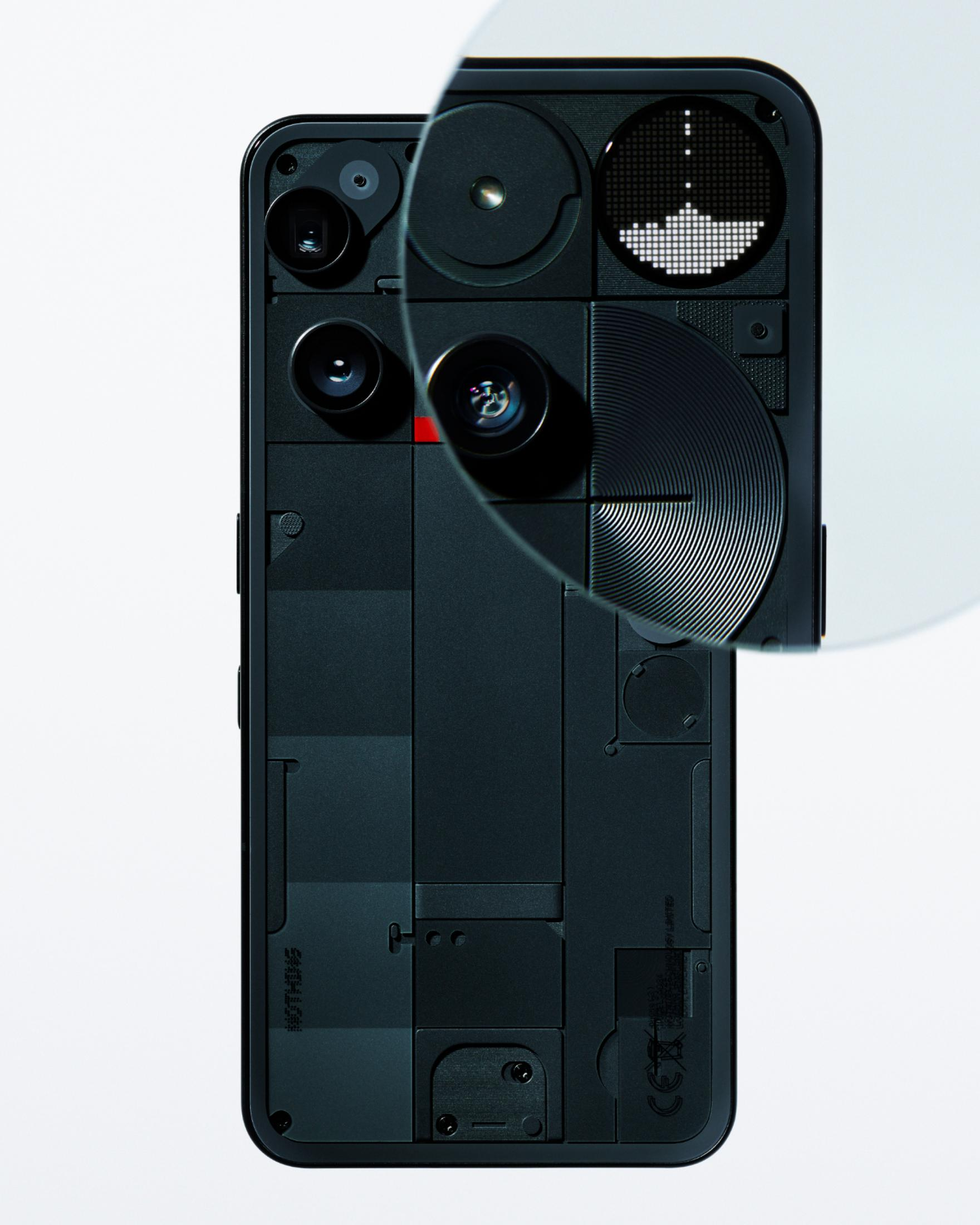 Czarny tył smartfona. Widoczne elementy: kamery, czerwony akcent i okrągły wyświetlacz LED z grafiką.