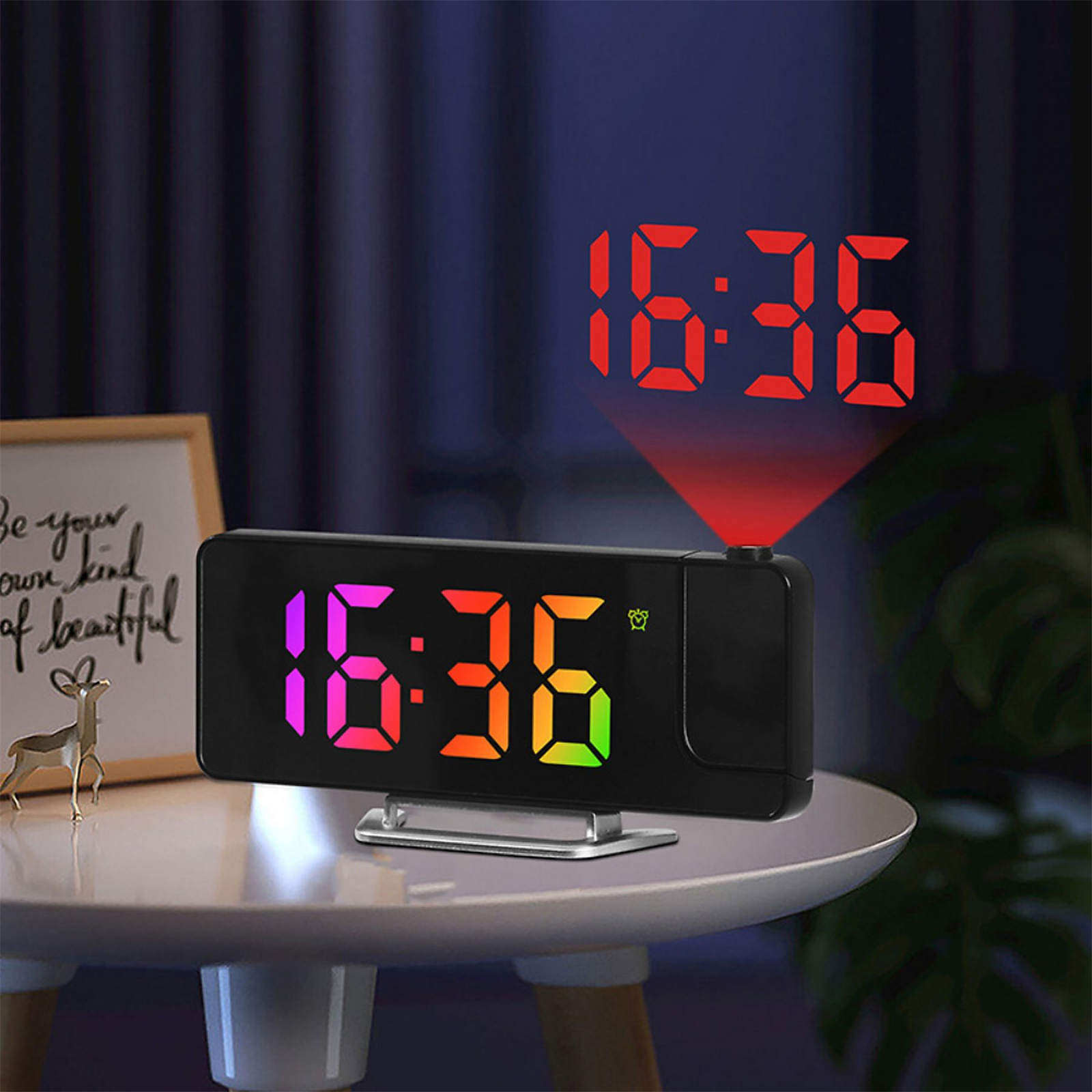 Digitaluhr, die 16:36 anzeigt, mit projizierter Anzeige an der Wand. Ein kleiner Tisch trägt die Uhr.