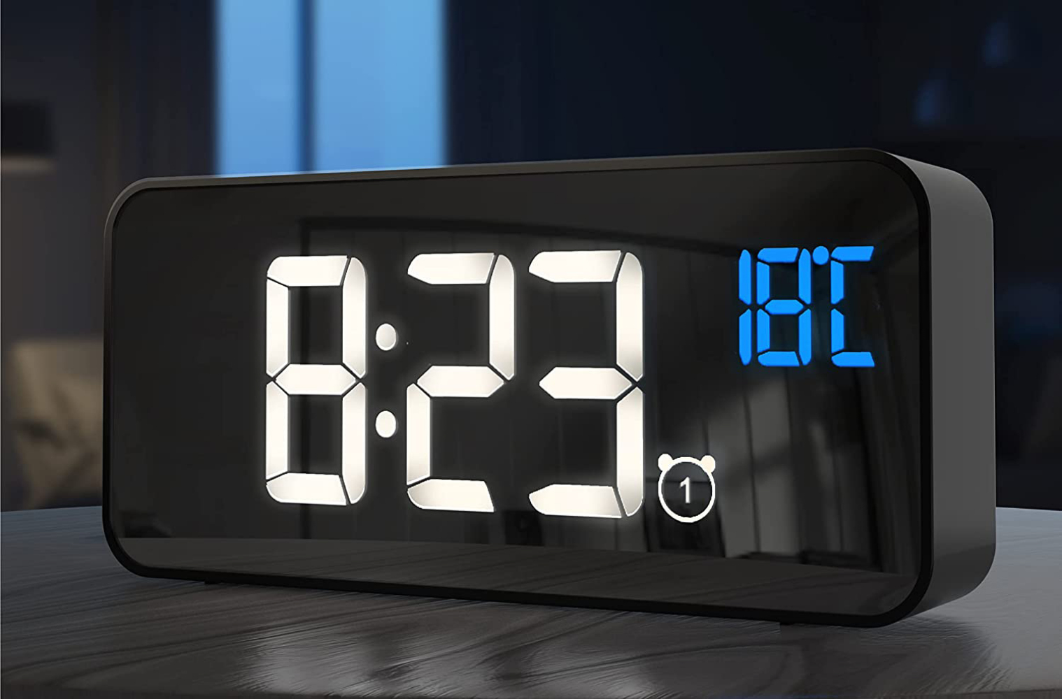 Eine Digitaluhr zeigt 8:23 und 18°C an. Sie ist schwarz mit weißen und blauen Ziffern. Das Alarmsymbol ist sichtbar.
