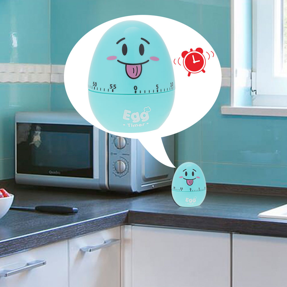 Ein blauer Eieruhr mit Gesicht, Mikrowelle und eine kleine Version des Timers in einer Küchenumgebung.