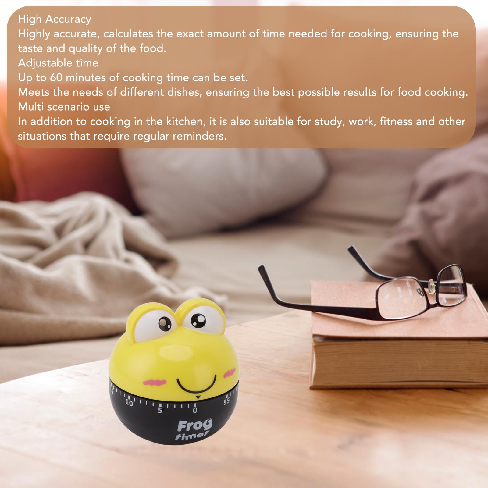 Ein gelber froschförmiger Timer mit schwarzem Sockel. Brille und ein Buch liegen auf der Holzoberfläche. Der Hintergrund ist unscharf.