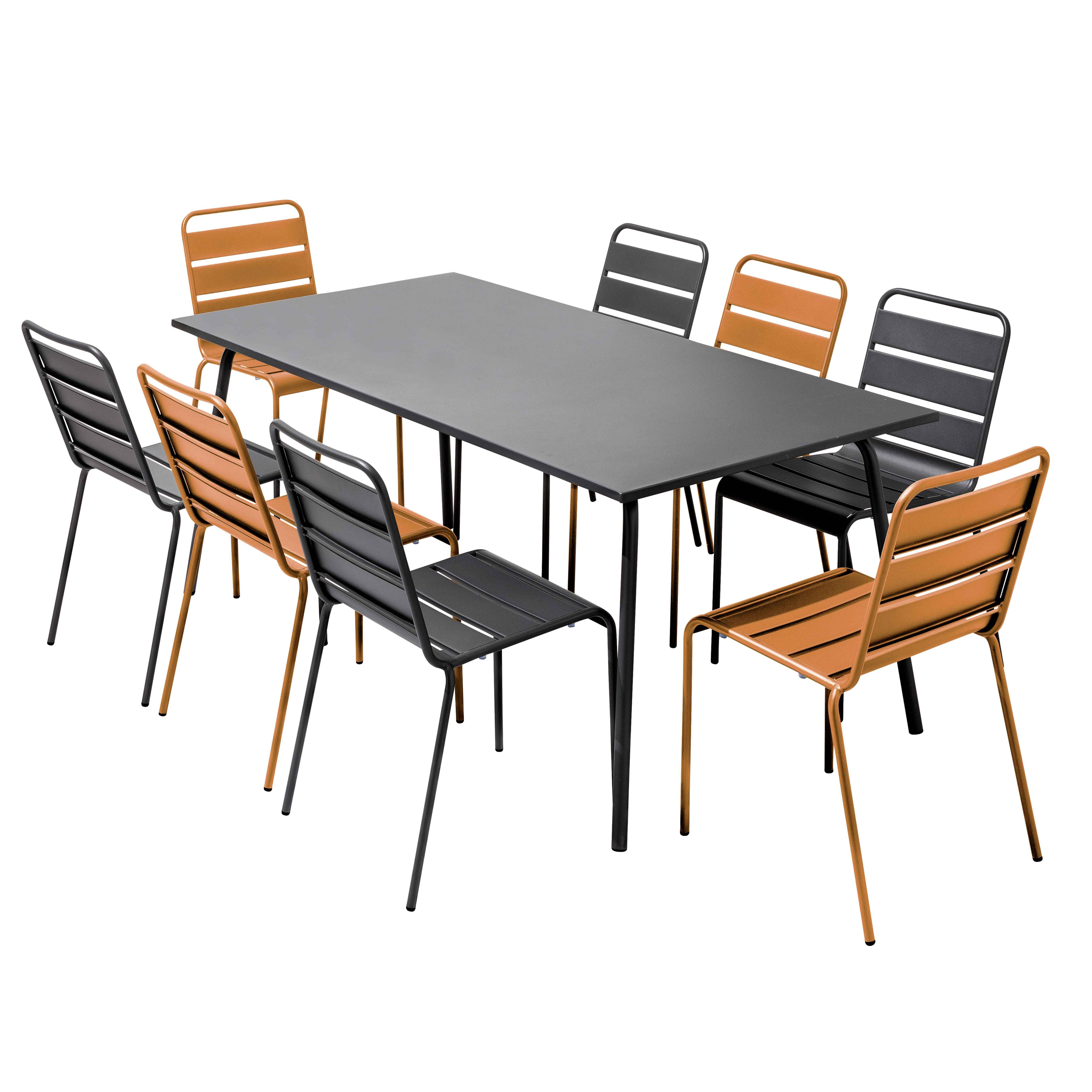 Ein schwarzer rechteckiger Tisch mit acht Stühlen darum. Die Stühle sind in zwei Farben: schwarz und orange.