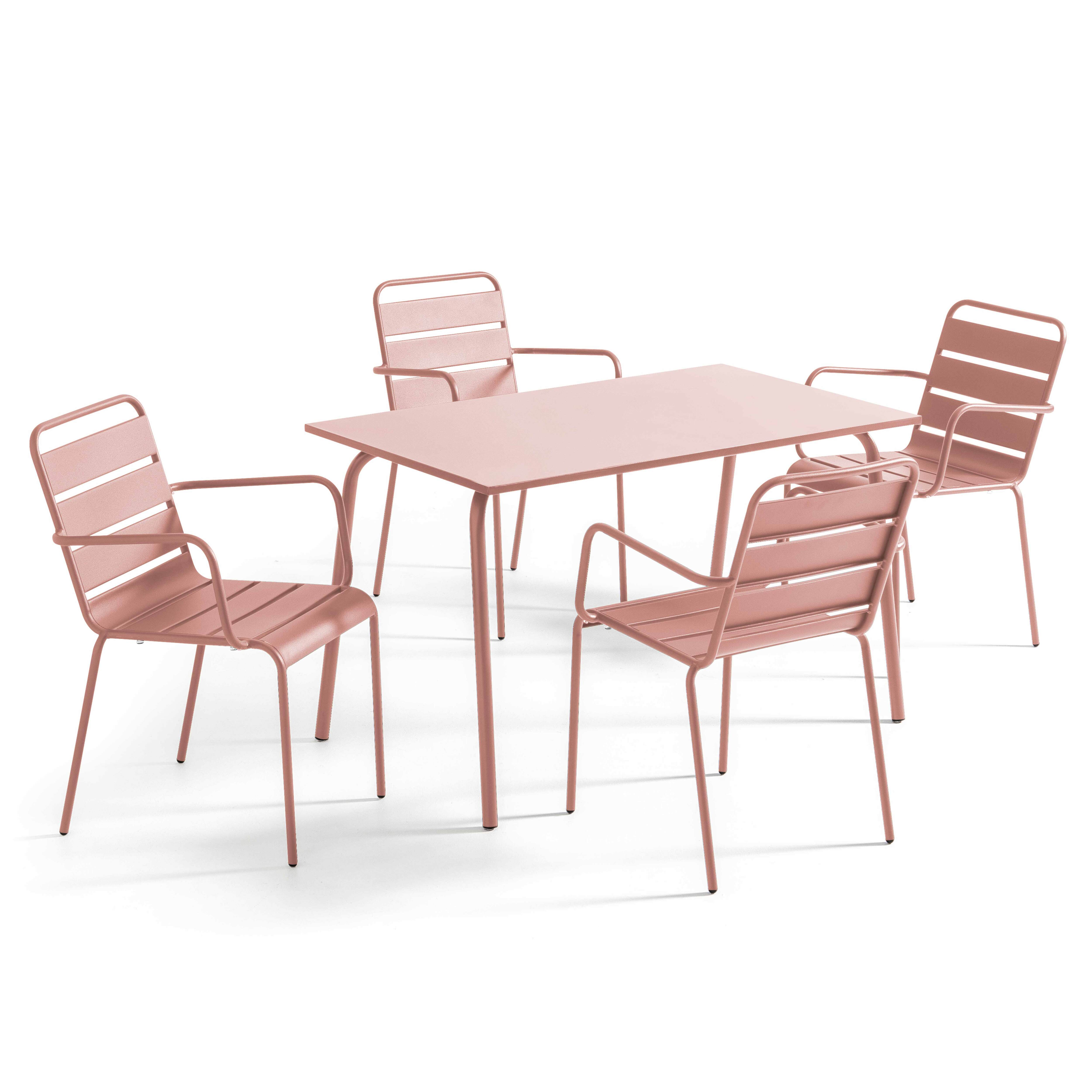 Vier rosa Metallstühle um einen passenden Tisch, alles auf weißem Hintergrund. Die Stühle haben Armlehnen und Lattenrücken.