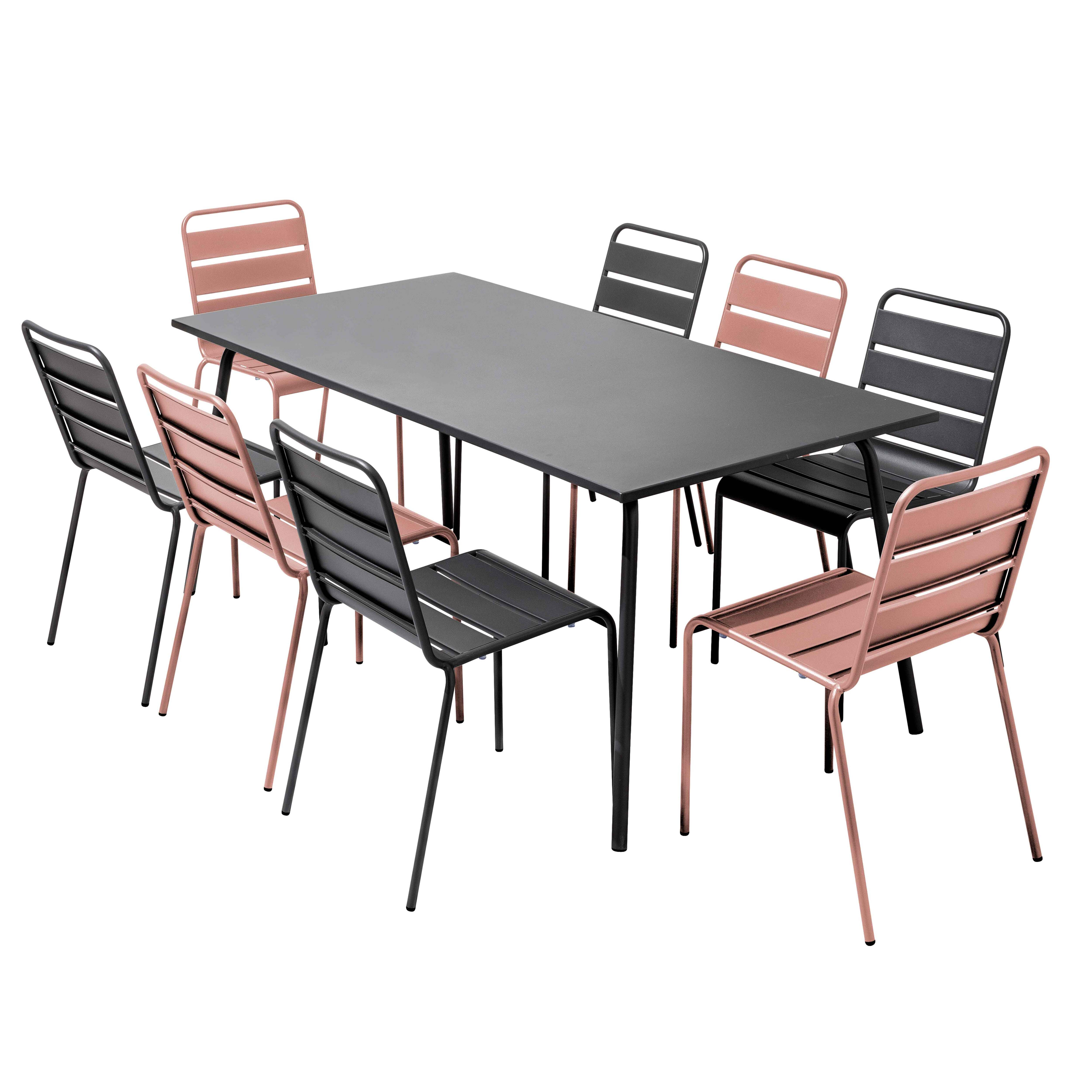 Ein schwarzer rechteckiger Tisch, umgeben von acht Stühlen. Stühle wechseln sich in Schwarz und Rosa ab, alle mit Metallrahmen.