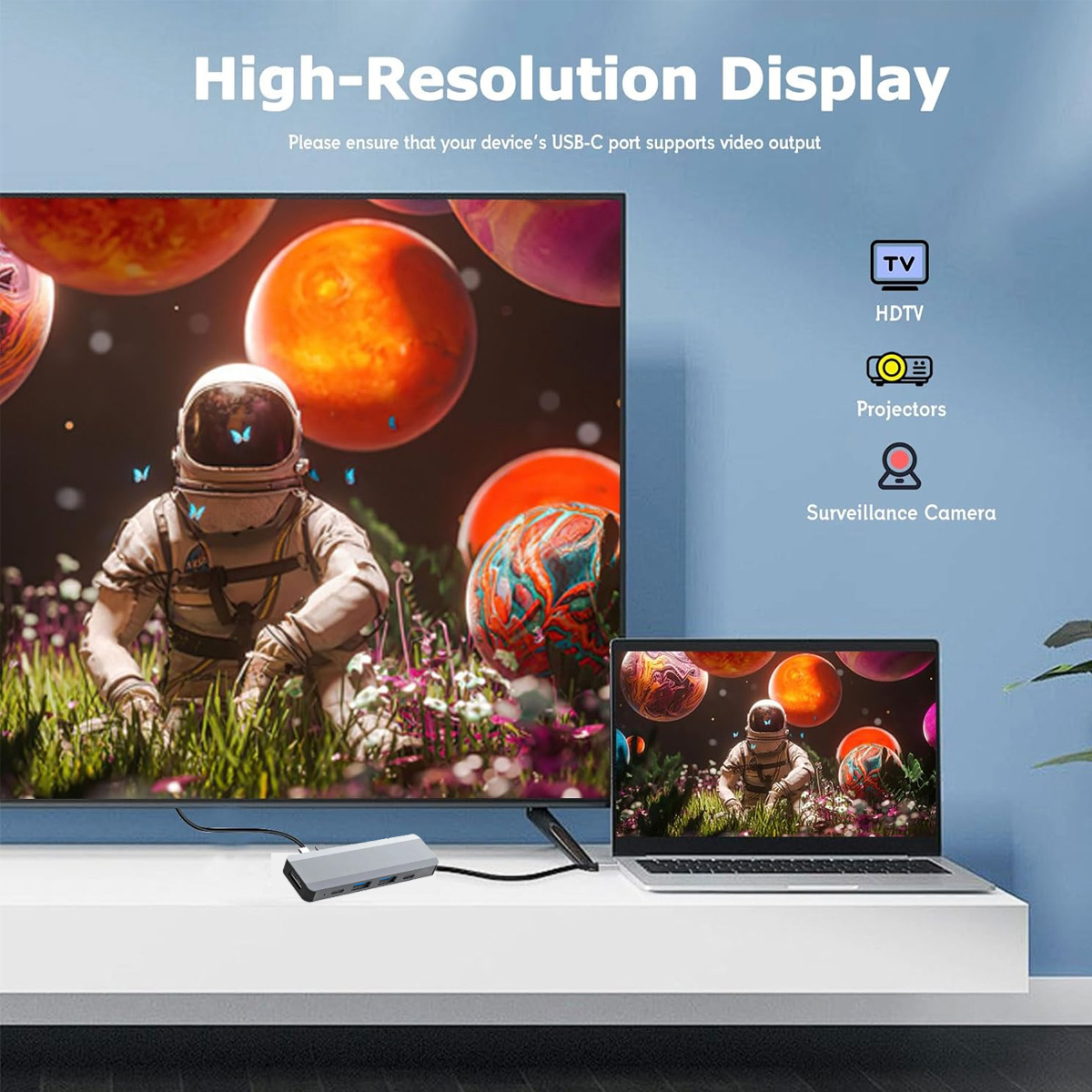 Astronaut in einer surrealen Szene auf einem Fernseher. Daneben ein Laptop. Ein Hub verbindet sich mit Fernseher und Laptop. Text erwähnt hochauflösende Anzeige.