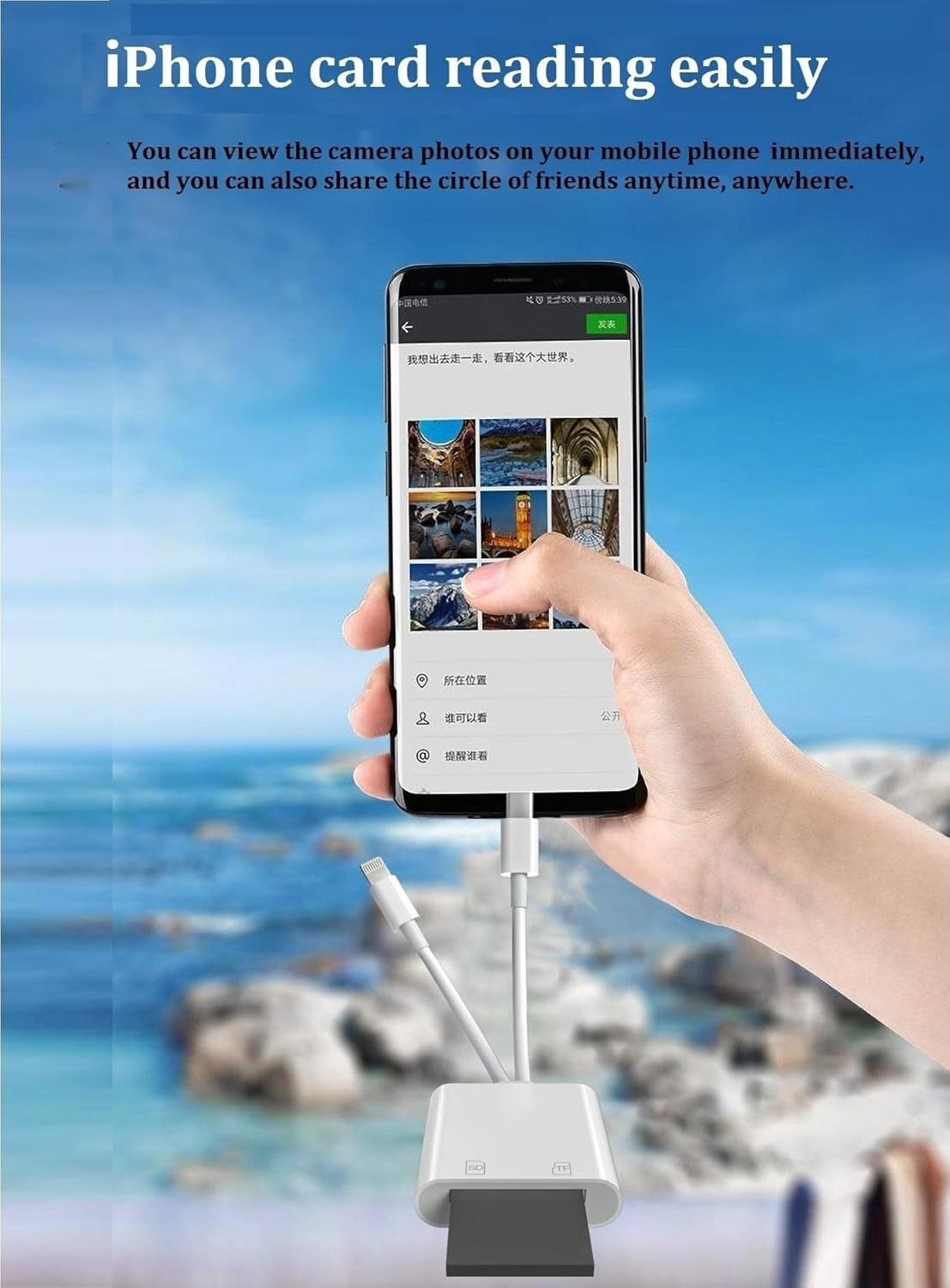 Eine Hand hält ein Telefon, das Fotos zeigt, verbunden mit einem Kartenleser. Der Hintergrund ist ein verschwommenes Meer.