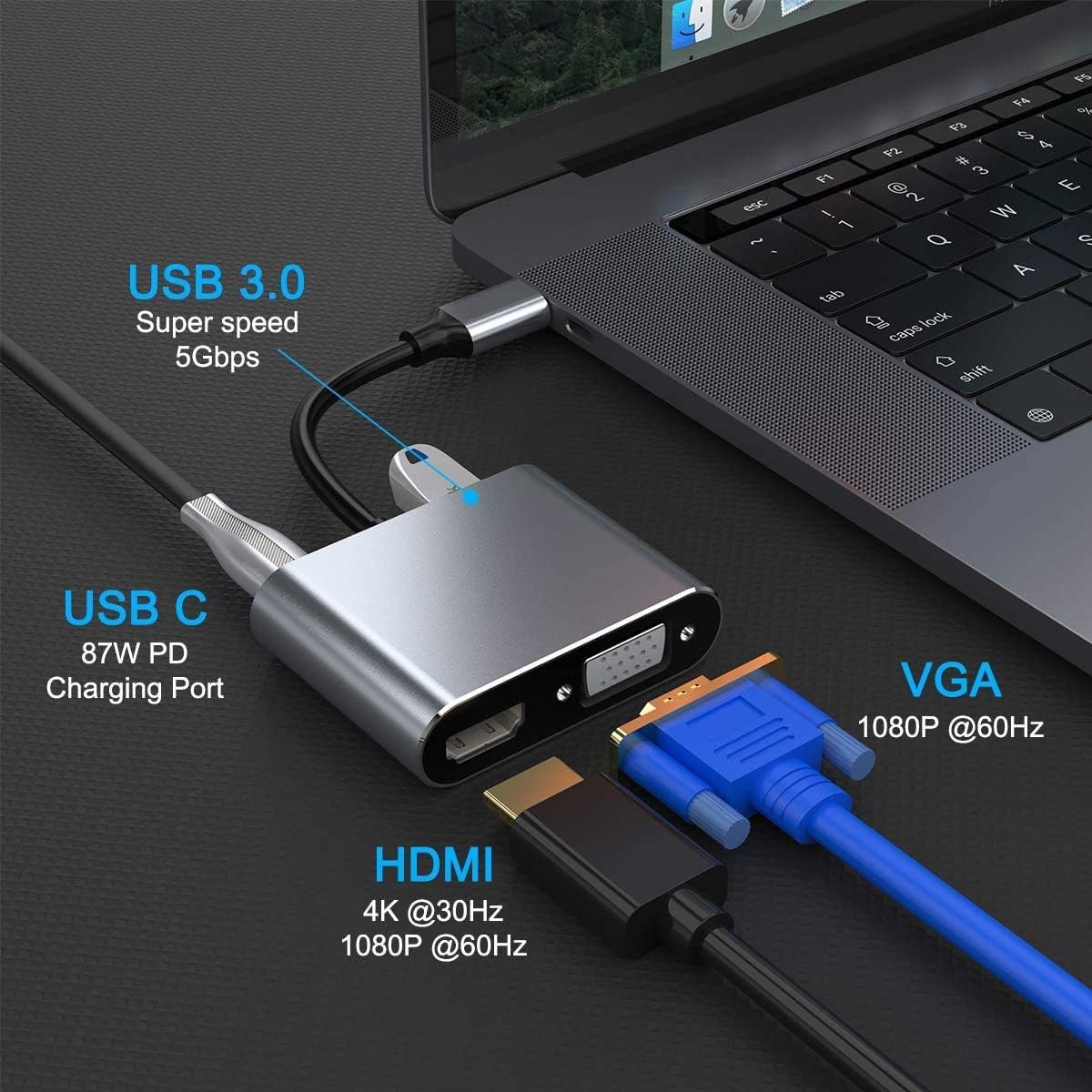 Ein silberner USB-Hub mit angeschlossenen Kabeln: USB-C, HDMI, VGA. Im Hintergrund ein Laptop, alles auf dunkler Oberfläche.