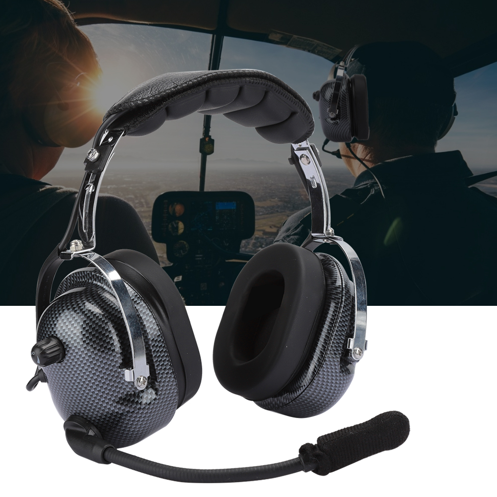 Pilot-Headset mit Ohrhörern aus Kohlefaser und Mikrofon. Im Hintergrund sind Personen im Cockpit eines Hubschraubers zu sehen.