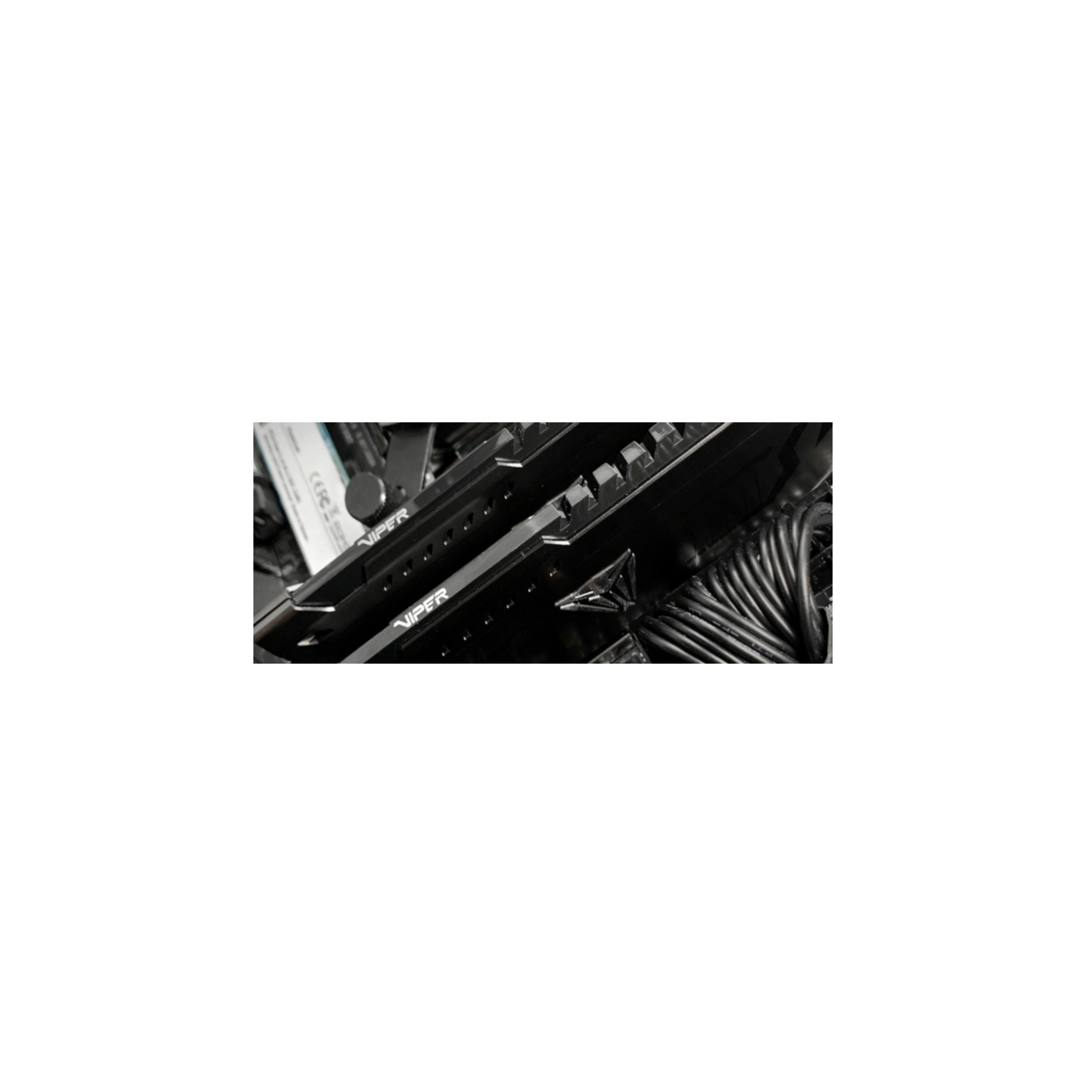 Czarne kości RAM z logo Viper. Kable i inne komponenty komputera w tle.