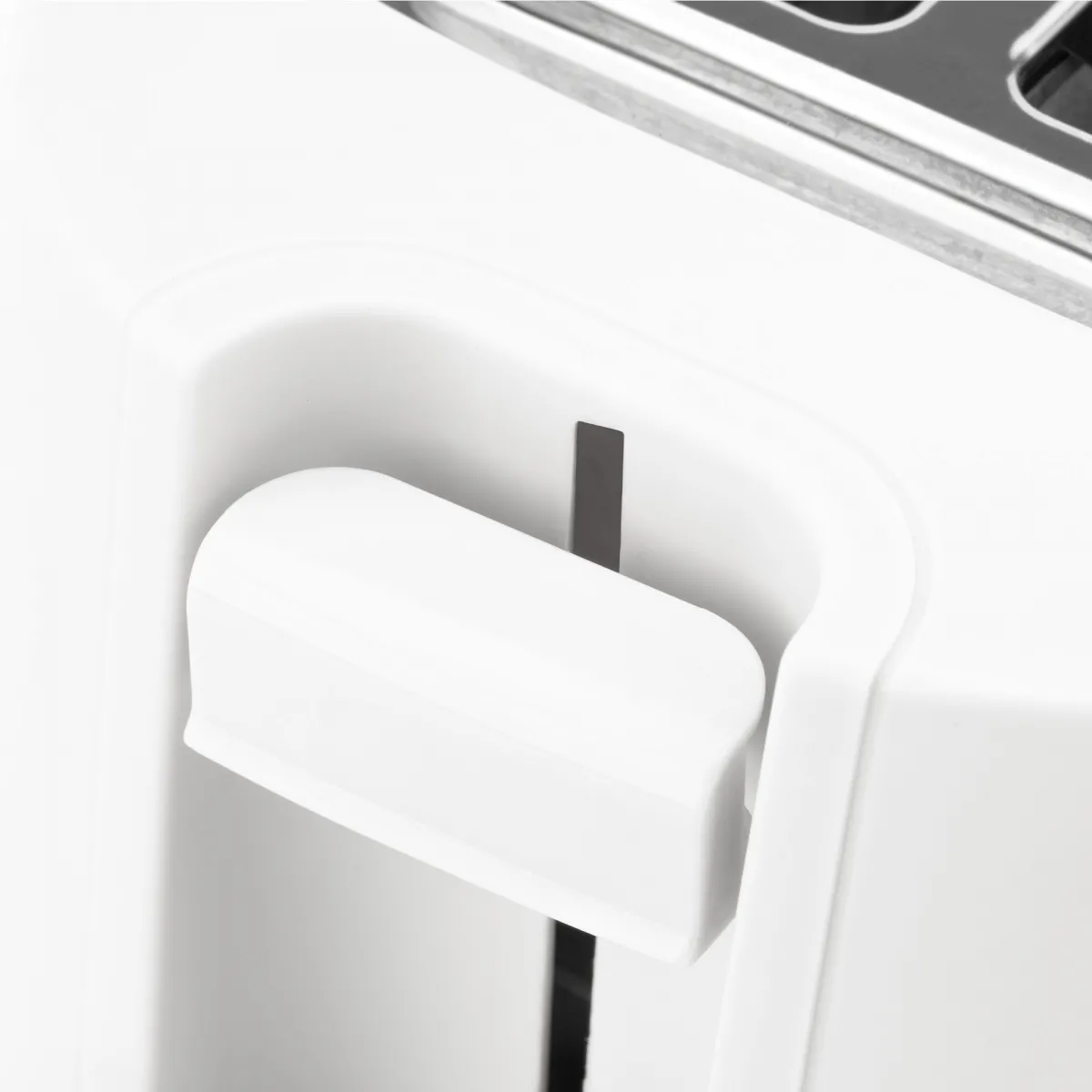 Zbliżenie białej dźwigni tostera. Dźwignia jest zakrzywiona, z czarną szczeliną za nią. Tło jest białe.