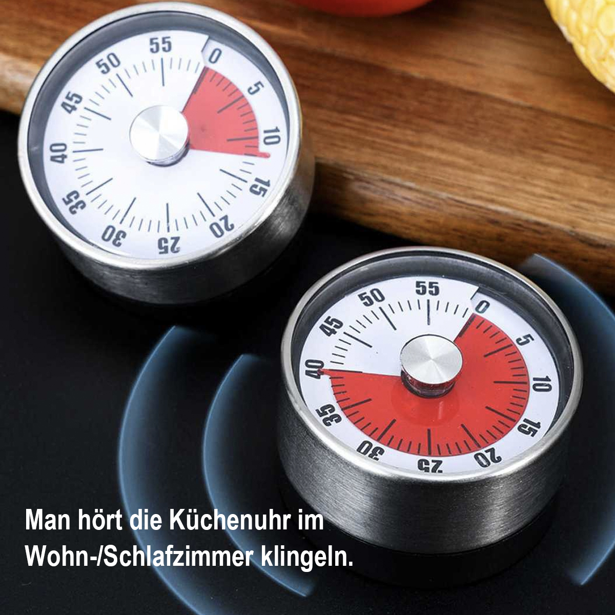 Zwei silberne Küchenwecker, einer auf schwarzem Untergrund, der andere auf Holz. Die Zifferblätter zeigen rote und weiße Abschnitte.