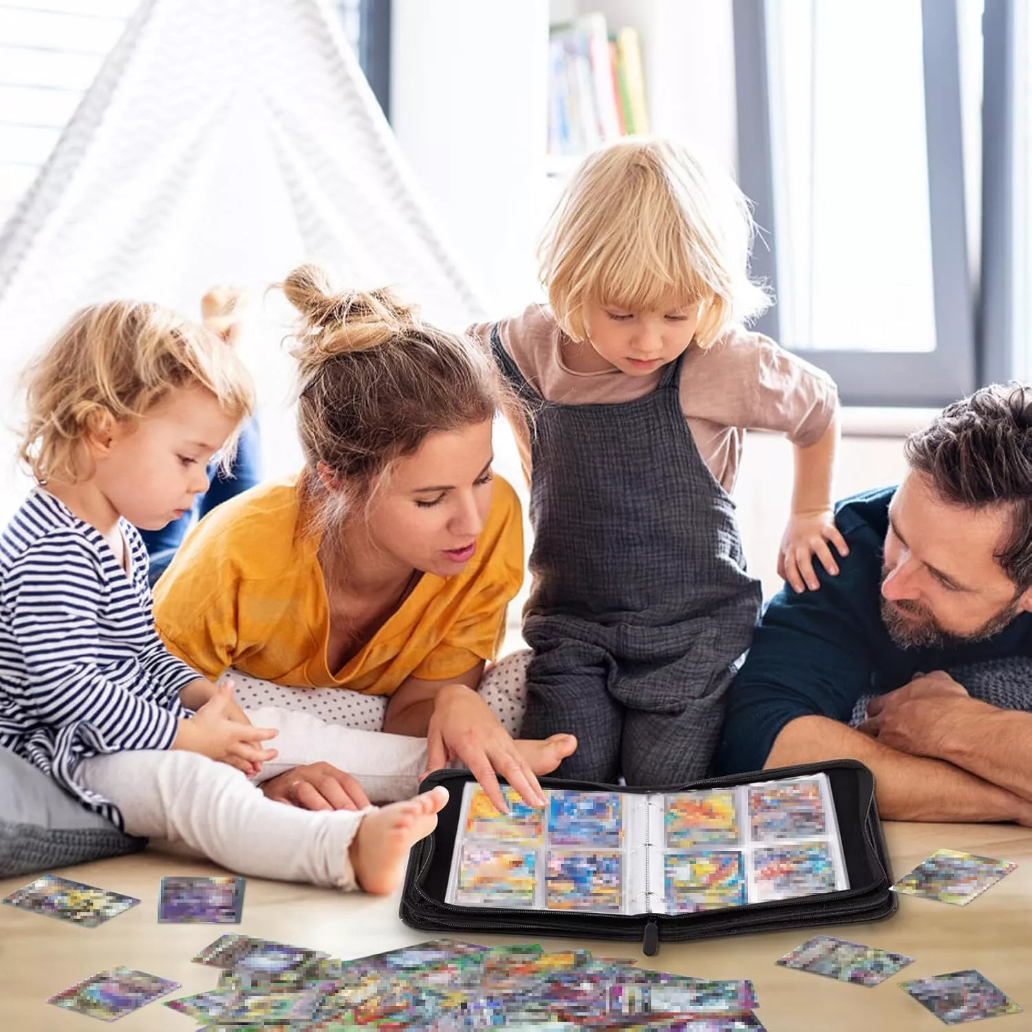 Familie betrachtet Sammelkarten in einem Ordner. Kinder und Eltern sind versammelt. Karten liegen auf dem Holzboden.