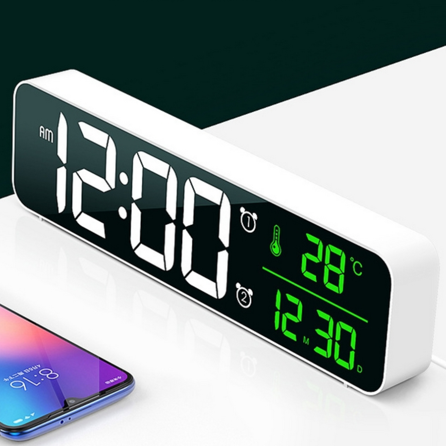 Eine Digitaluhr zeigt 12:00 AM an. Sie zeigt 28°C und das Datum 12.30. Auf der Oberfläche liegt ein Smartphone mit der Uhrzeit 8:16.