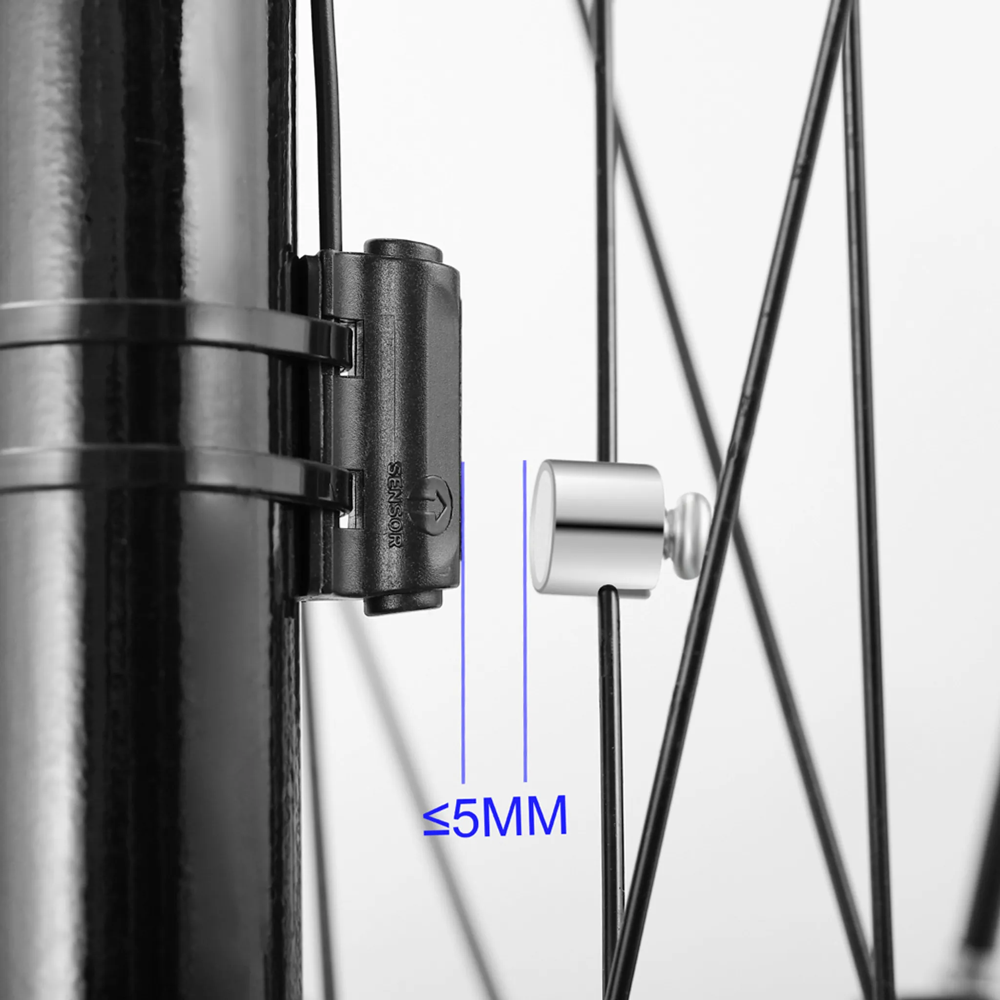 Nahaufnahme eines Fahrradradsensors, schwarzer Rahmen, silberner Sensor und Speichen. Text beschriftet 5mm Abstand.