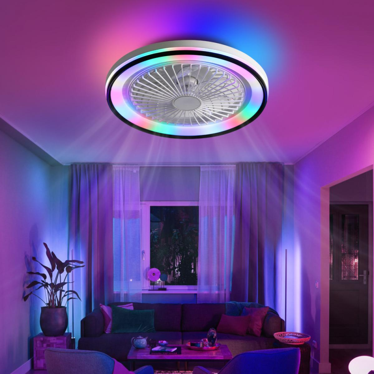 Ein Deckenventilator mit bunten Lichtern beleuchtet ein Wohnzimmer. Ein Sofa, eine Pflanze und ein Fenster sind zu sehen. Der Raum ist in farbiges Licht getaucht.