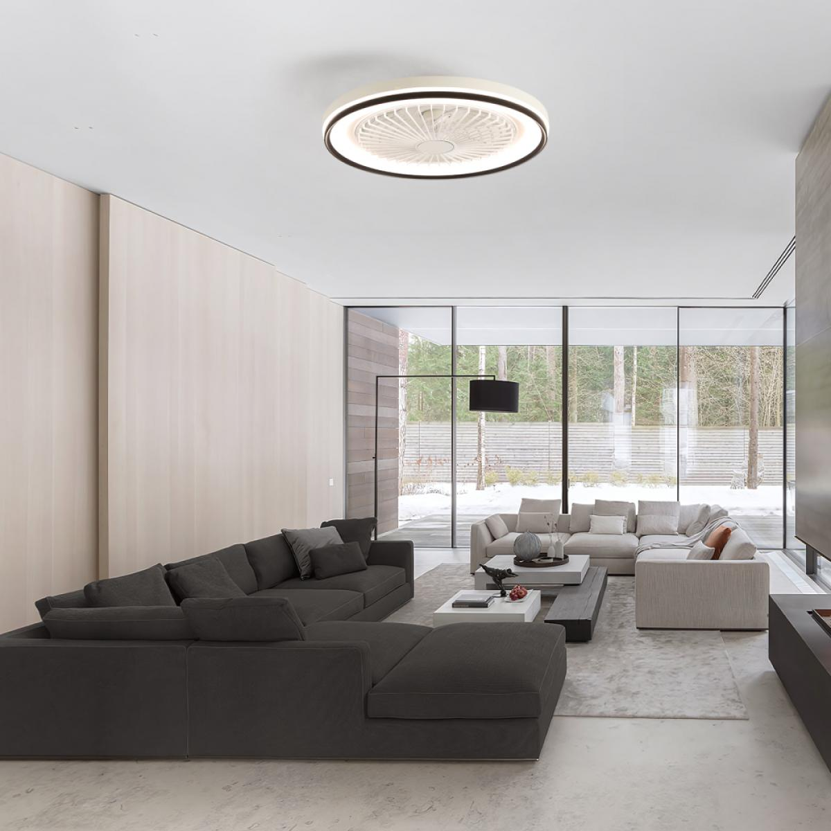 Modernes Wohnzimmer mit dunkelgrauem Ecksofa, Deckenventilator, großen Fenstern, hellfarbigem Sofa und Blick nach draußen mit Schnee.