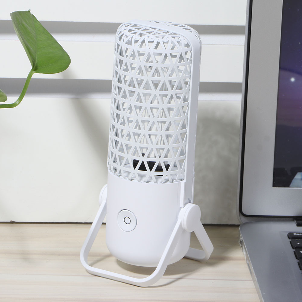 Weißer Luftreiniger mit geometrischem Design, neben einem Laptop und einem grünen Blatt.
