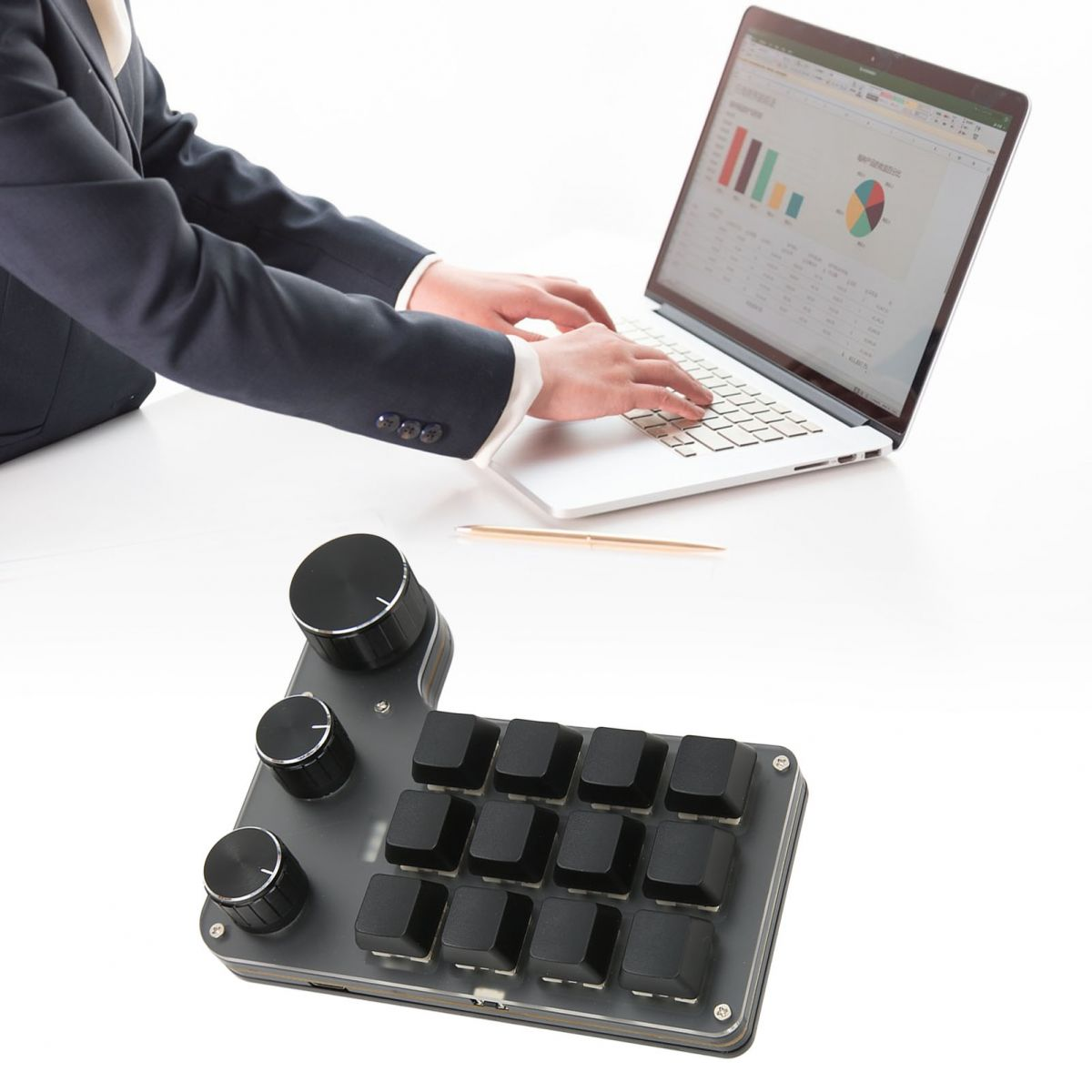 Eine Person benutzt einen Laptop mit geöffneter Tabelle. Eine benutzerdefinierte Tastatur mit Knöpfen und Tasten im Vordergrund.