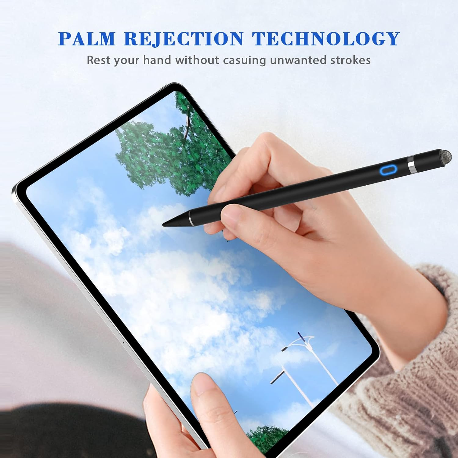 Eine Hand hält einen schwarzen Stift über einem Tablet, das einen blauen Himmel und einen Baum zeigt. Das Tablet befindet sich vor einer Person, die einen Pullover trägt.