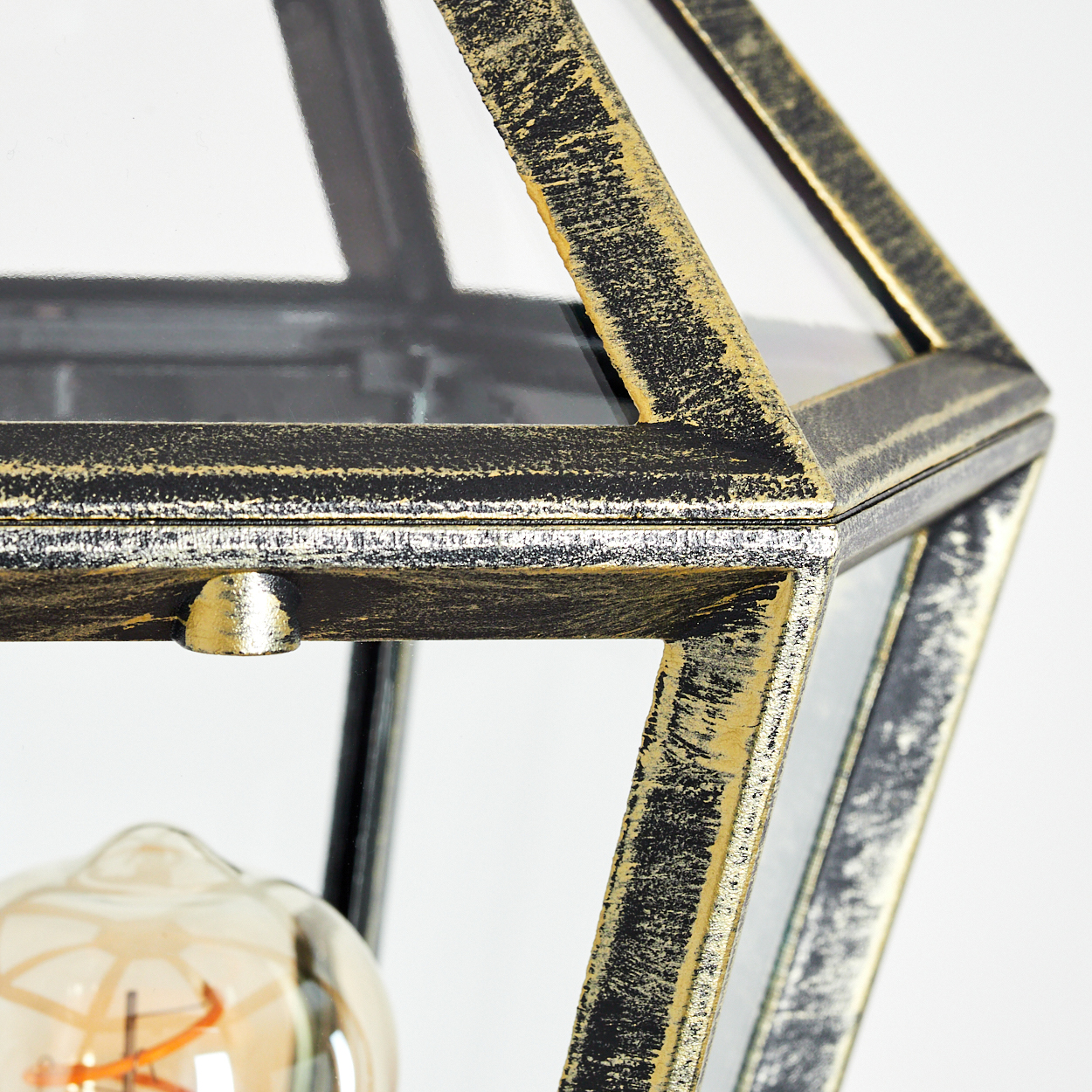 Nahaufnahme einer geometrischen Lampe mit Glasplatten und einem Vintage-Metallrahmen. Eine Glühbirne ist zu sehen. Weißer Hintergrund.
