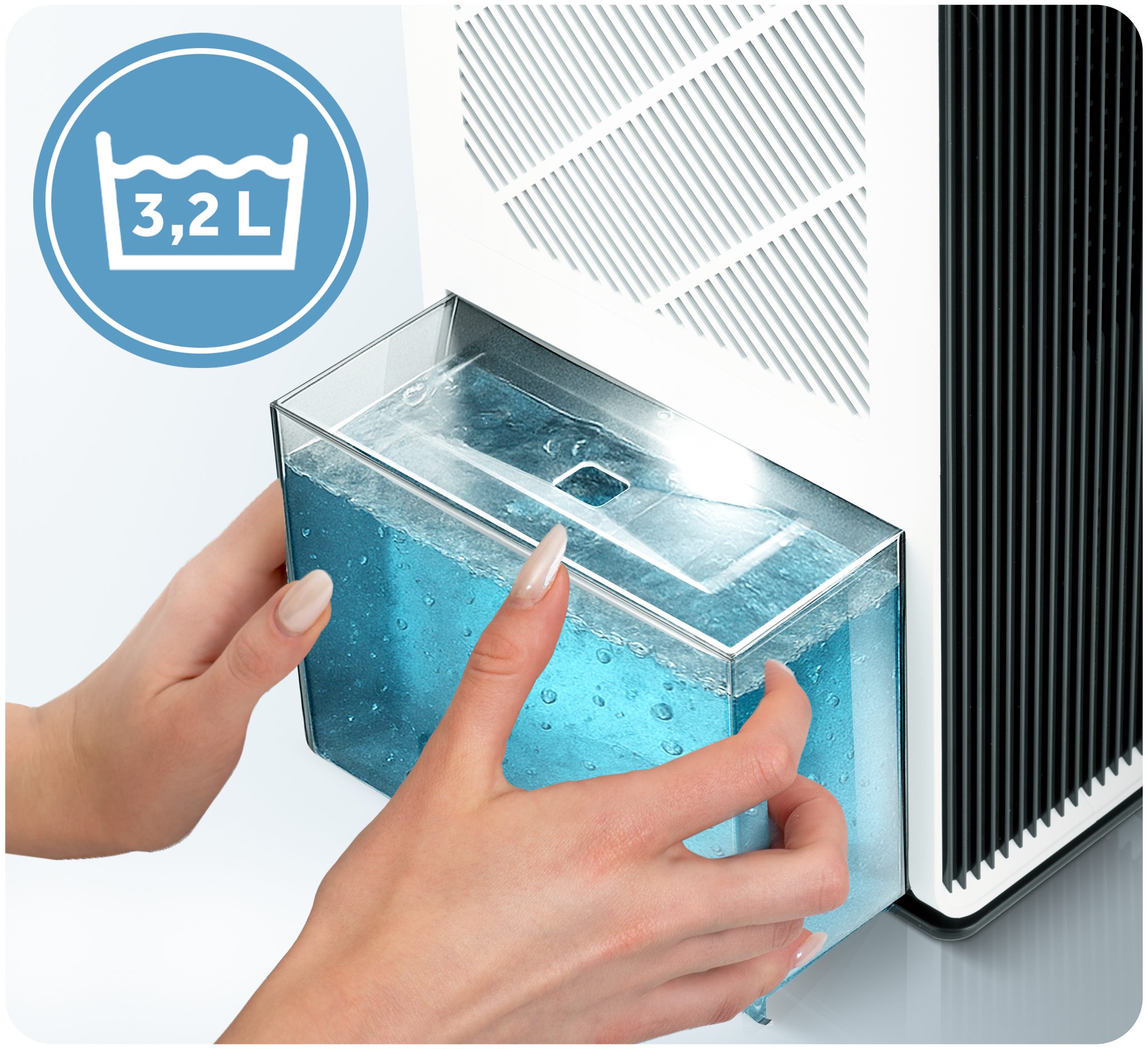 Dłonie trzymają zbiornik na wodę z niebieską wodą, część osuszacza powietrza. Niebieskie koło pokazuje pojemność 3,2L.