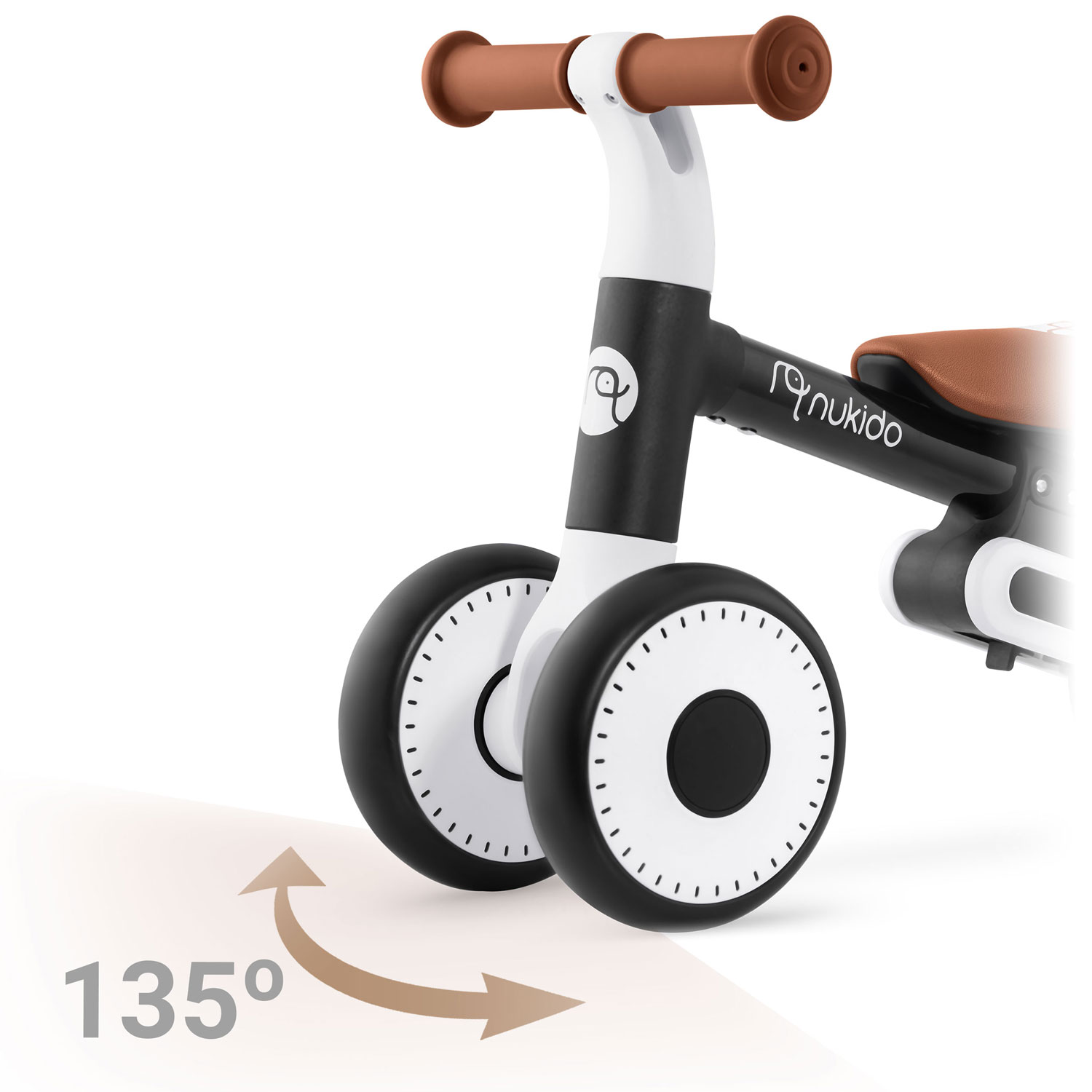 Rowerek biegowy dla dzieci z czarno-białą ramą, brązowym siedziskiem i kierownicą. Koła są czarno-białe. Strzałka wskazuje kąt 135 stopni.