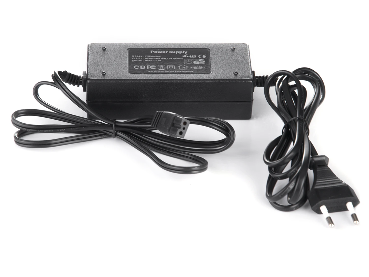 Czarny zasilacz z etykietą, kablami i wtyczką na białej powierzchni. Kable są zwinięte.