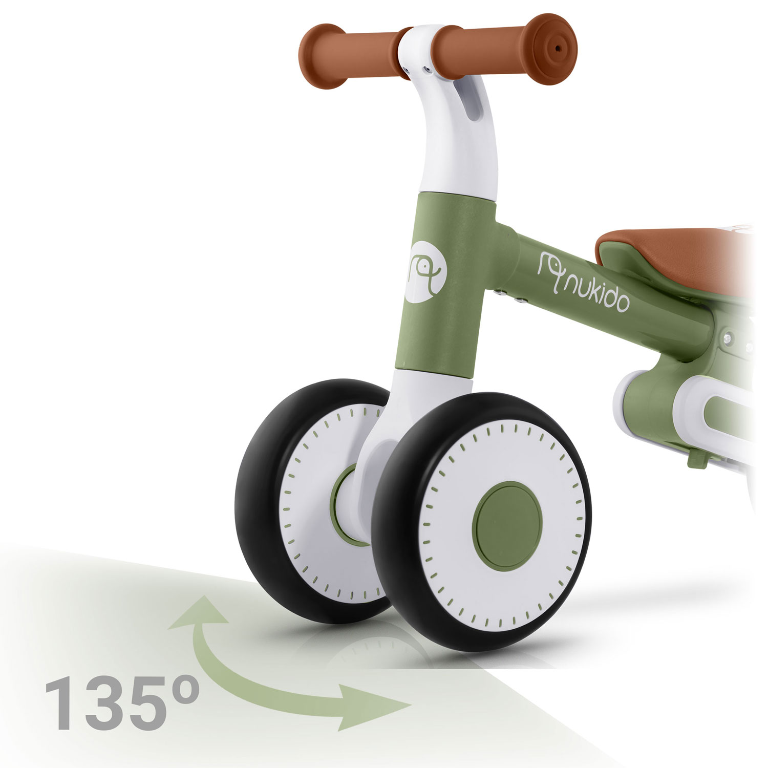 Zielony i biały rowerek biegowy z brązowymi uchwytami i siedzeniem. Koła są czarne z białymi środkami. Strzałka 135 stopni po lewej.