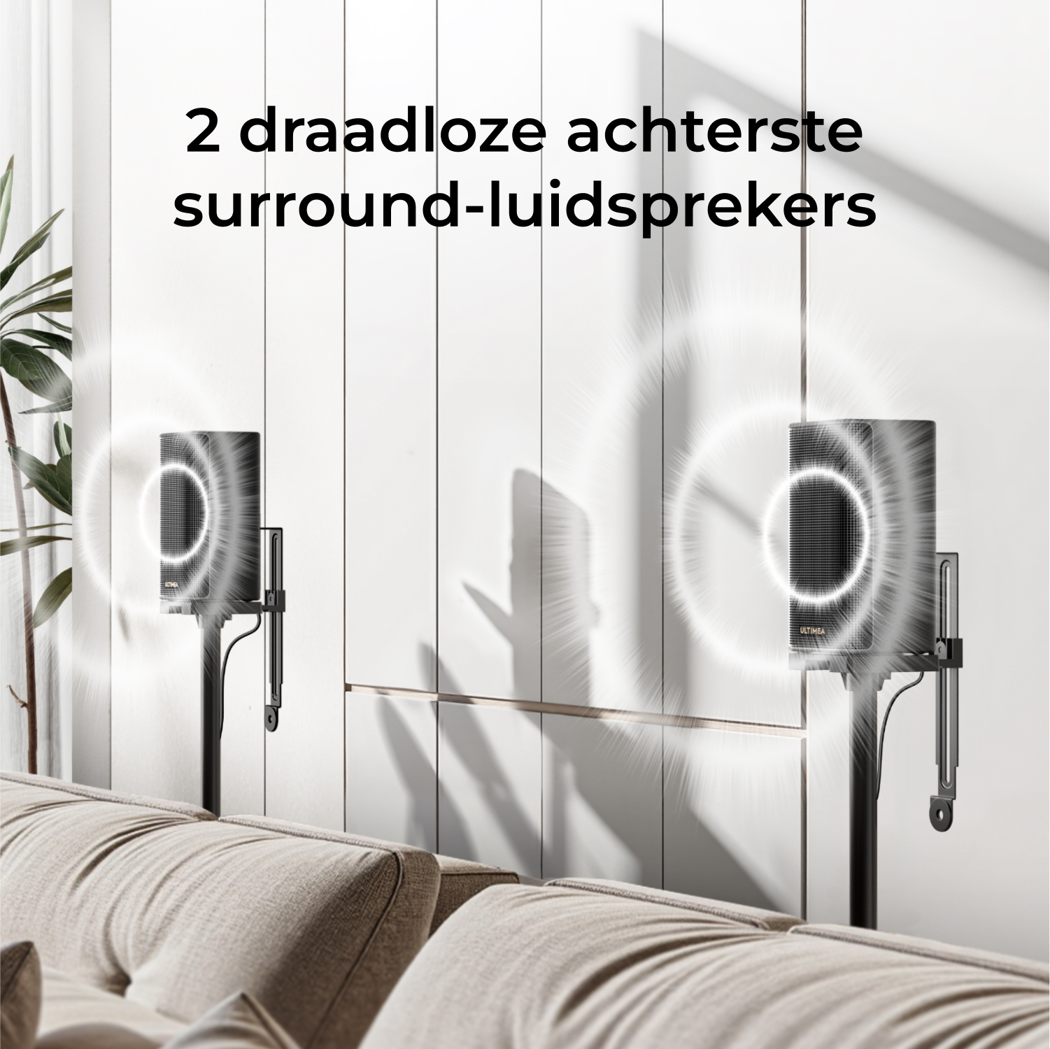Deux enceintes surround sans fil noires sur pieds, avec graphiques d'ondes sonores, sur un mur blanc, au-dessus d'un canapé beige.