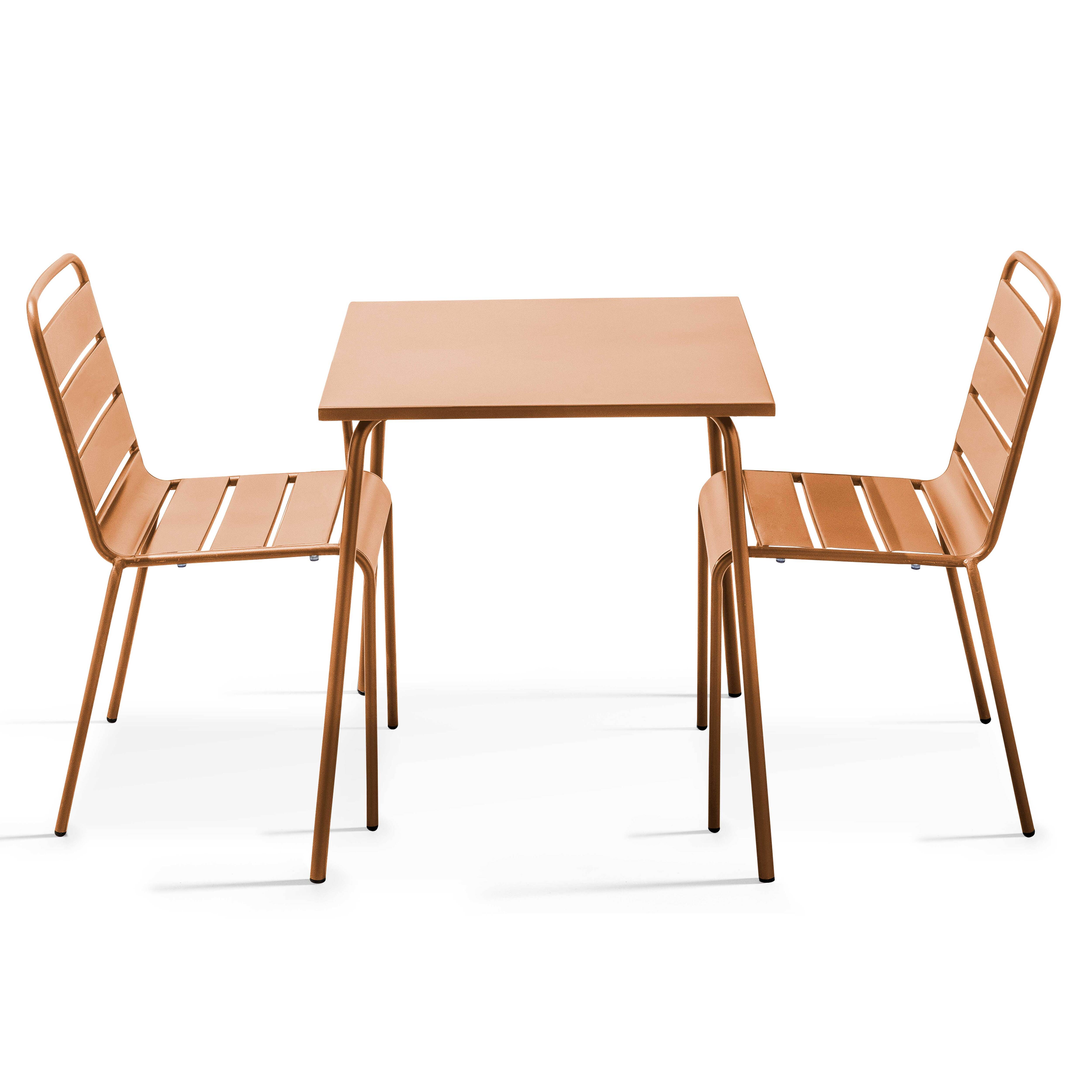 Zwei kupferfarbene Stühle und ein Tisch auf weißem Hintergrund. Der Tisch steht zwischen den Stühlen.