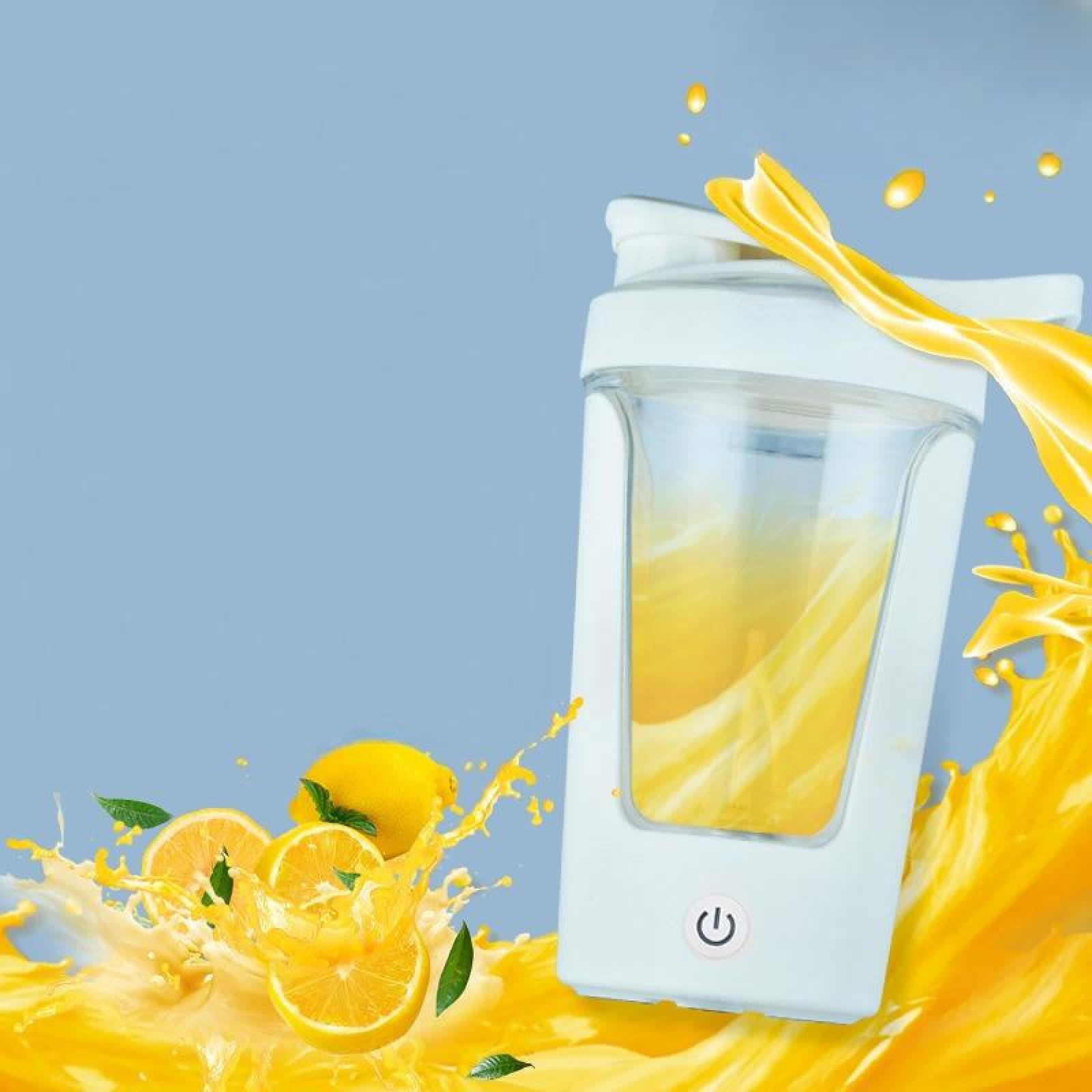 Ein weißer Mixer mit Saftspritzern, Zitronen und Scheiben auf blauem Hintergrund.