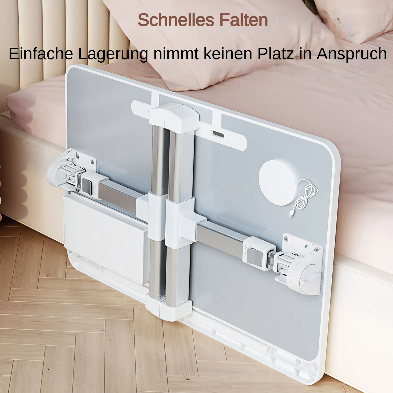Klappbarer Laptop-Schreibtisch. Graue Oberfläche, weißer Rahmen, mit verstellbaren Beinen. Rosa Bett und Holzboden im Hintergrund.