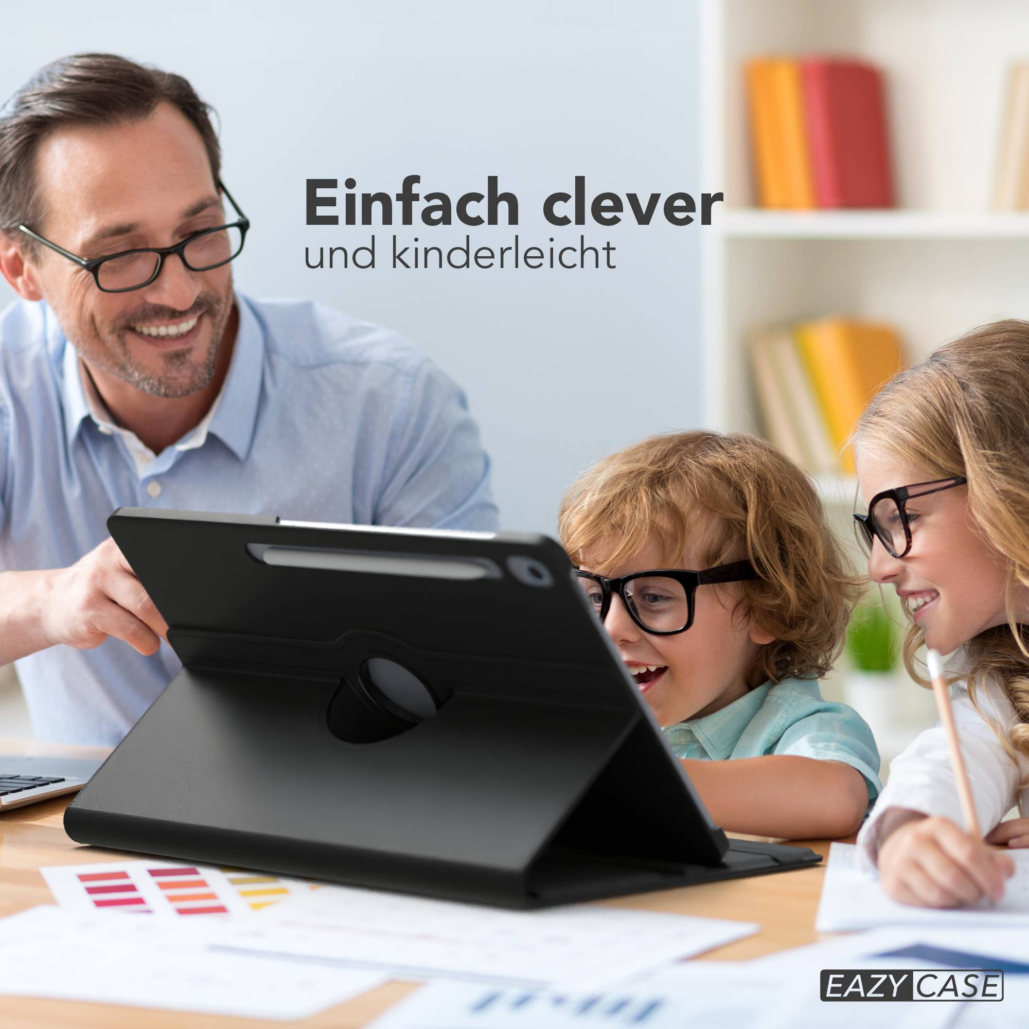 Mann und zwei Kinder mit Brille schauen auf ein Tablet. Das Tablet liegt auf einem Tisch mit Papieren.