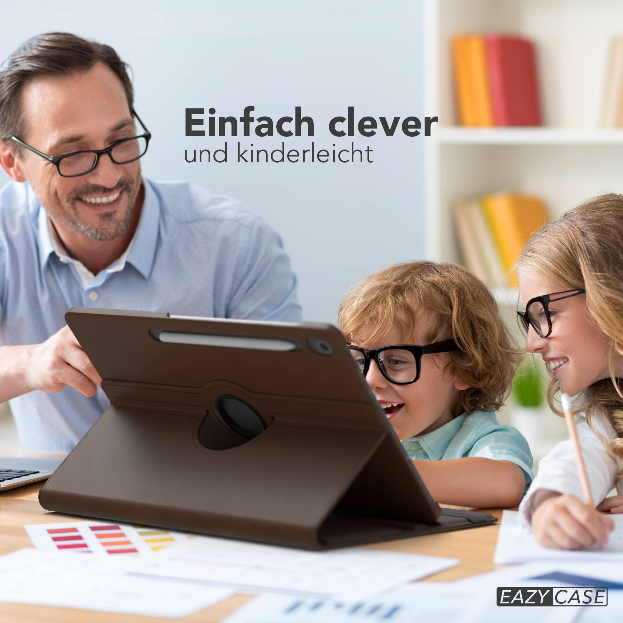 Ein Mann und zwei Kinder mit Brille schauen auf ein Tablet in einer braunen Hülle. Ein Bleistift und Papiere liegen auf dem Tisch.