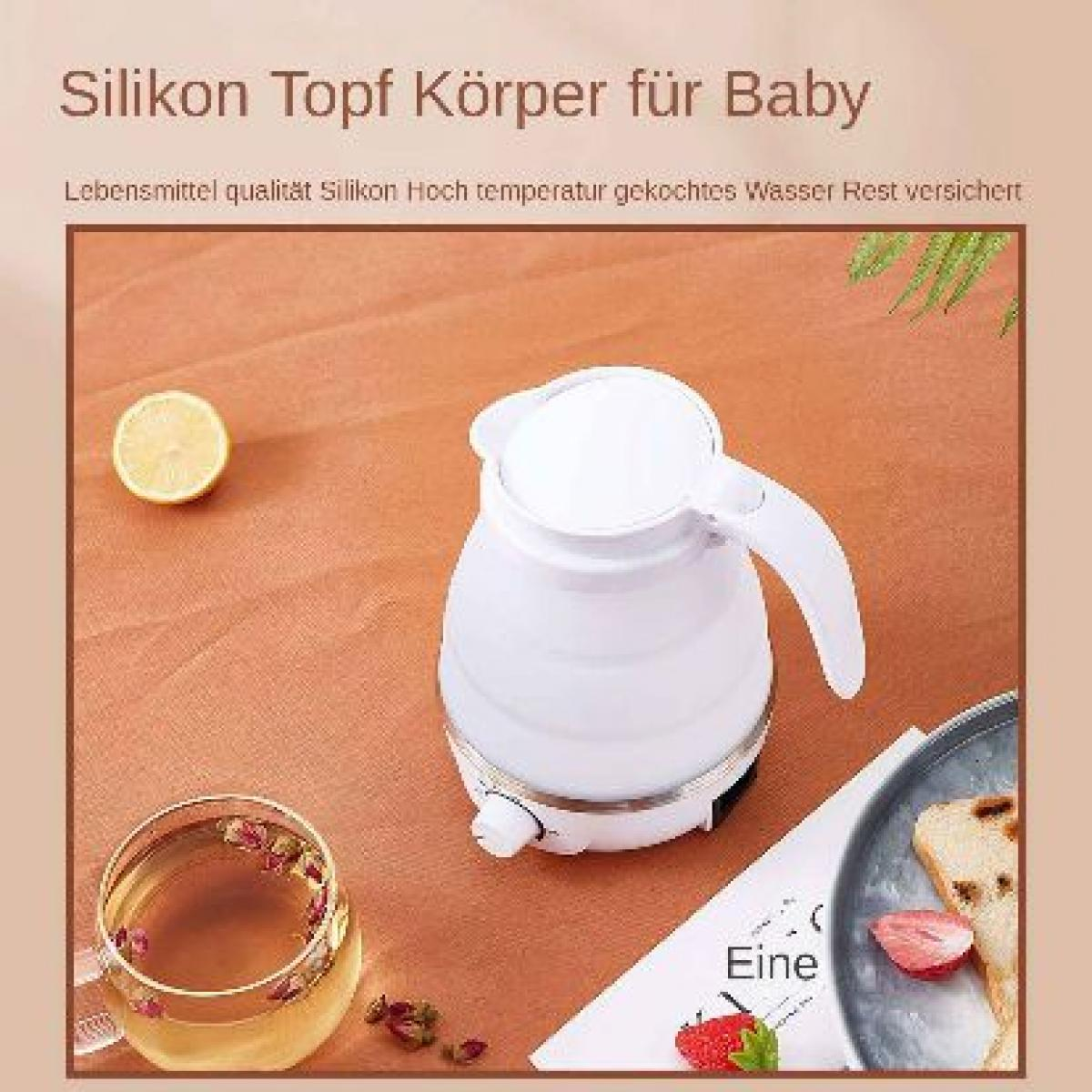 Ein weißer Wasserkocher, eine Zitronenhälfte, ein Glas Tee mit Rosenblättern und ein Teller mit Brot und einer Erdbeere.
