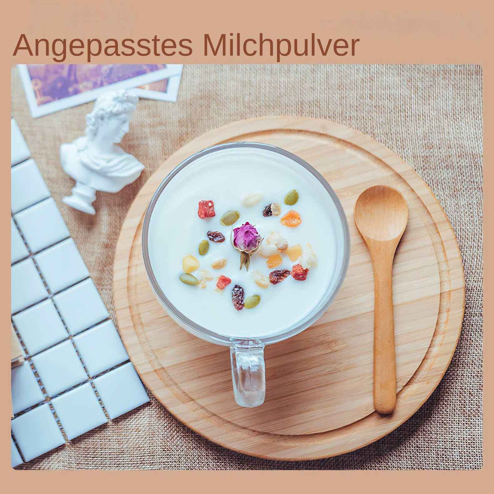 Ein Glas Milch mit Trockenfrüchten und einer Rose auf einem Holzbrett mit einem Löffel und einer Büste.