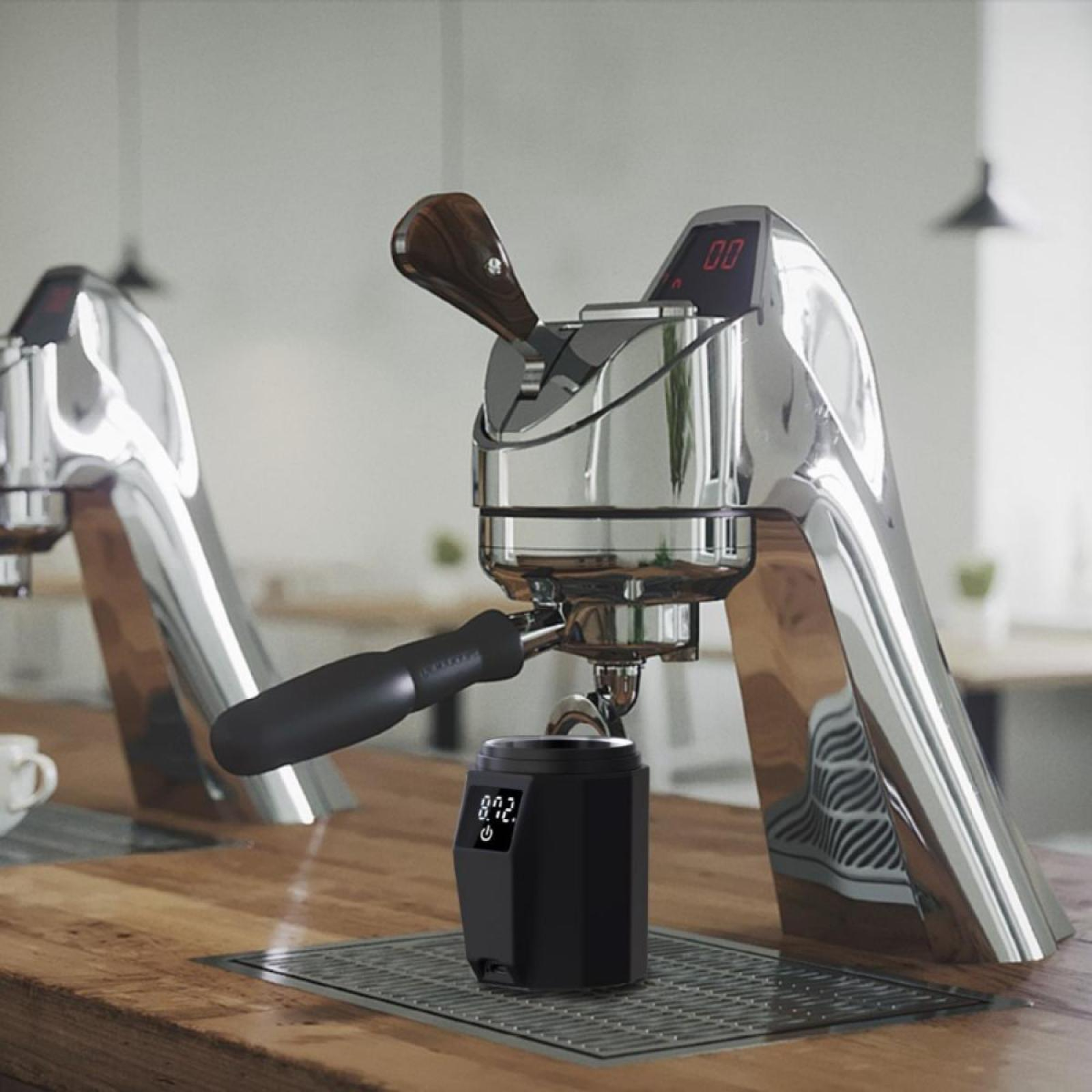 Eine verchromte Espressomaschine mit Holzgriff und Digitalanzeige auf einer Holzoberfläche. Vorne steht eine Mühle.