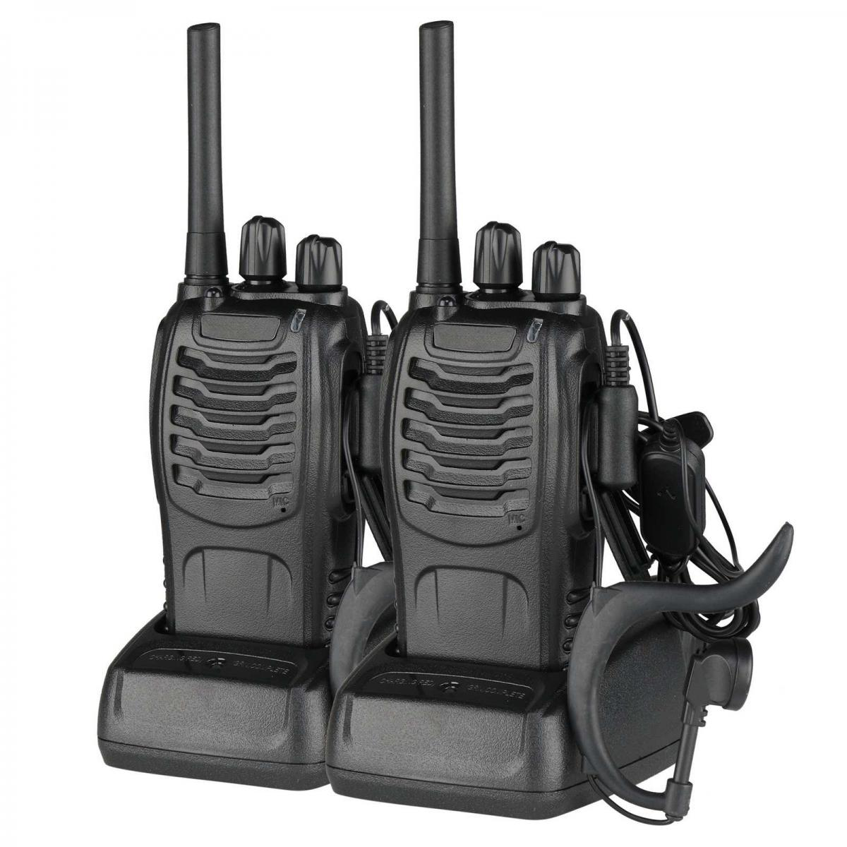 Zwei schwarze Walkie-Talkies mit Antennen und Ladestationen. Eines hat ein Headset.