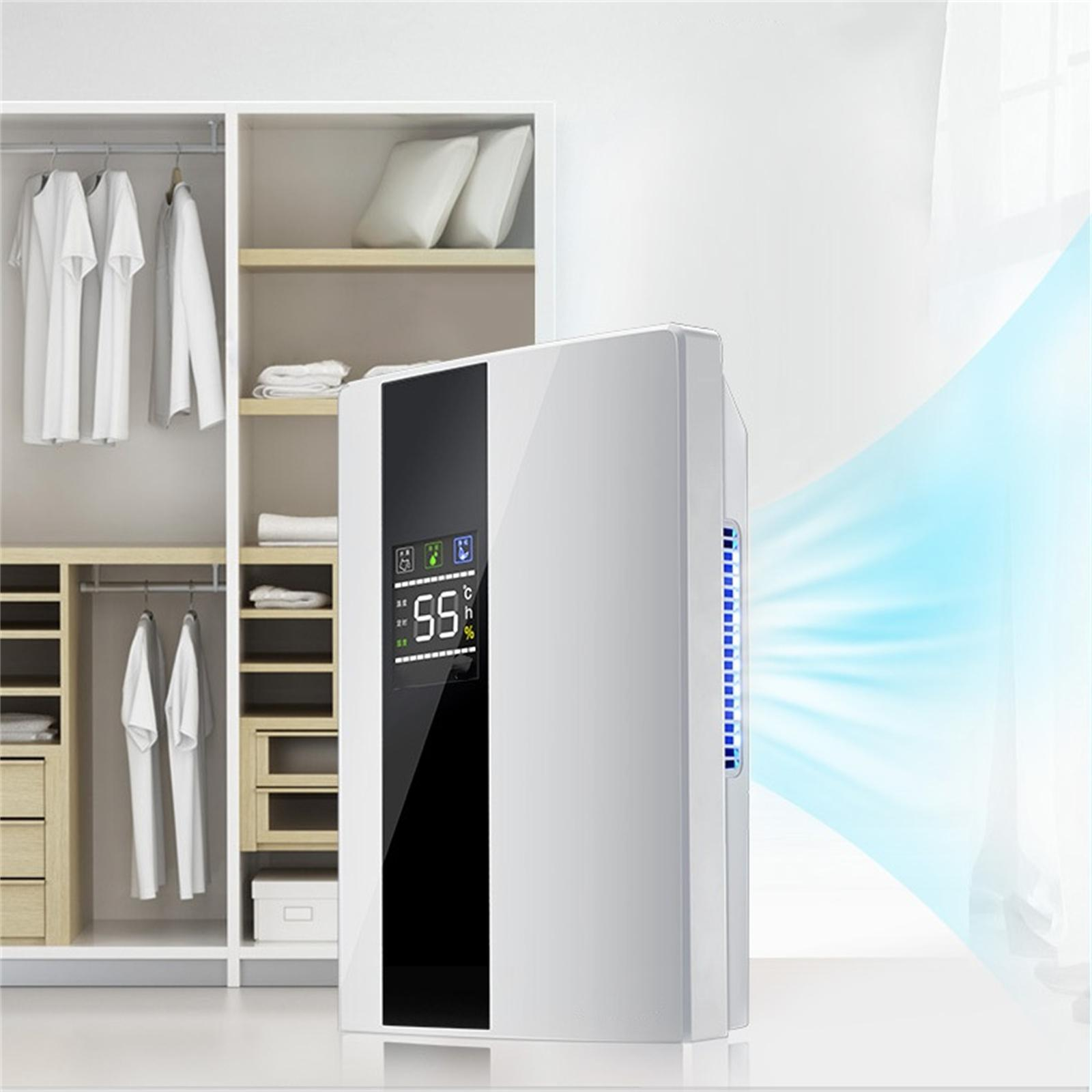 Ein weißer Luftentfeuchter mit digitaler Anzeige, die 55 % anzeigt. Im Hintergrund ein Kleiderschrank mit Kleidung.