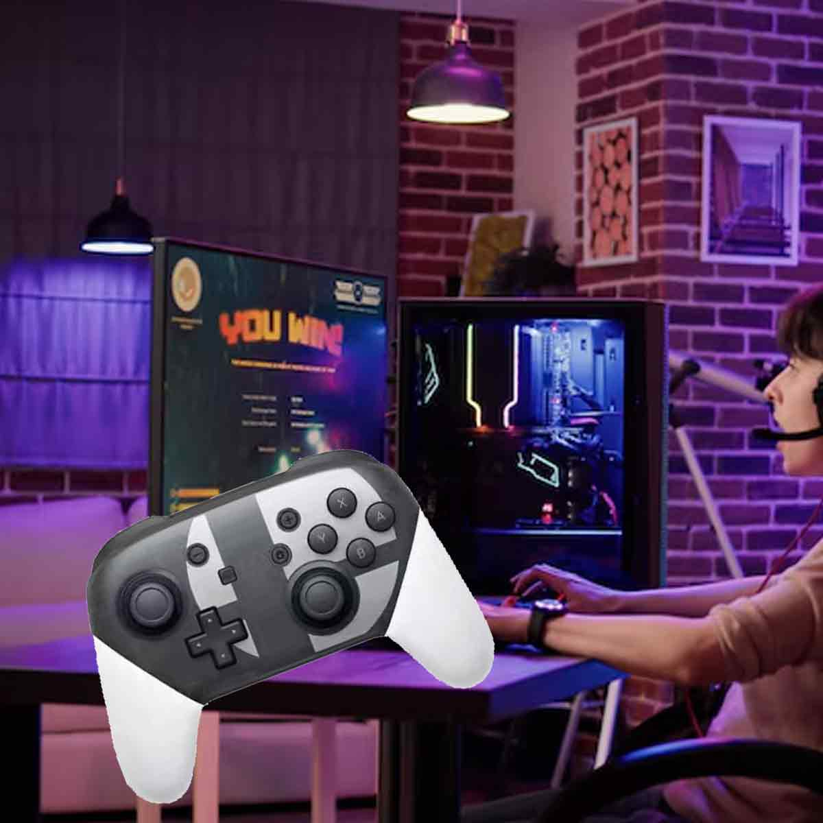 Ein Gaming-Setup mit einem Controller im Vordergrund. Eine Person spielt auf einem Computer mit einem 'You Win'-Bildschirm.