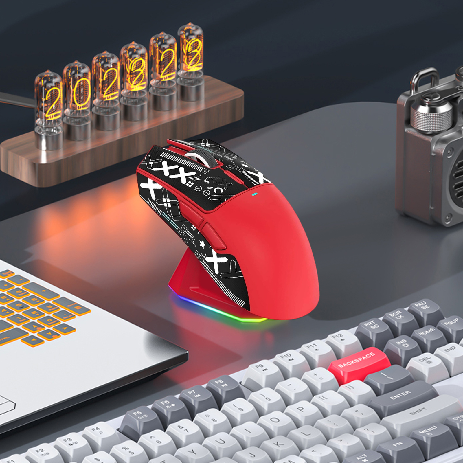 Eine rote Gaming-Maus mit schwarzer Oberseite steht auf einem Ständer. Eine Tastatur und eine Nixie-Röhrenuhr sind ebenfalls sichtbar.
